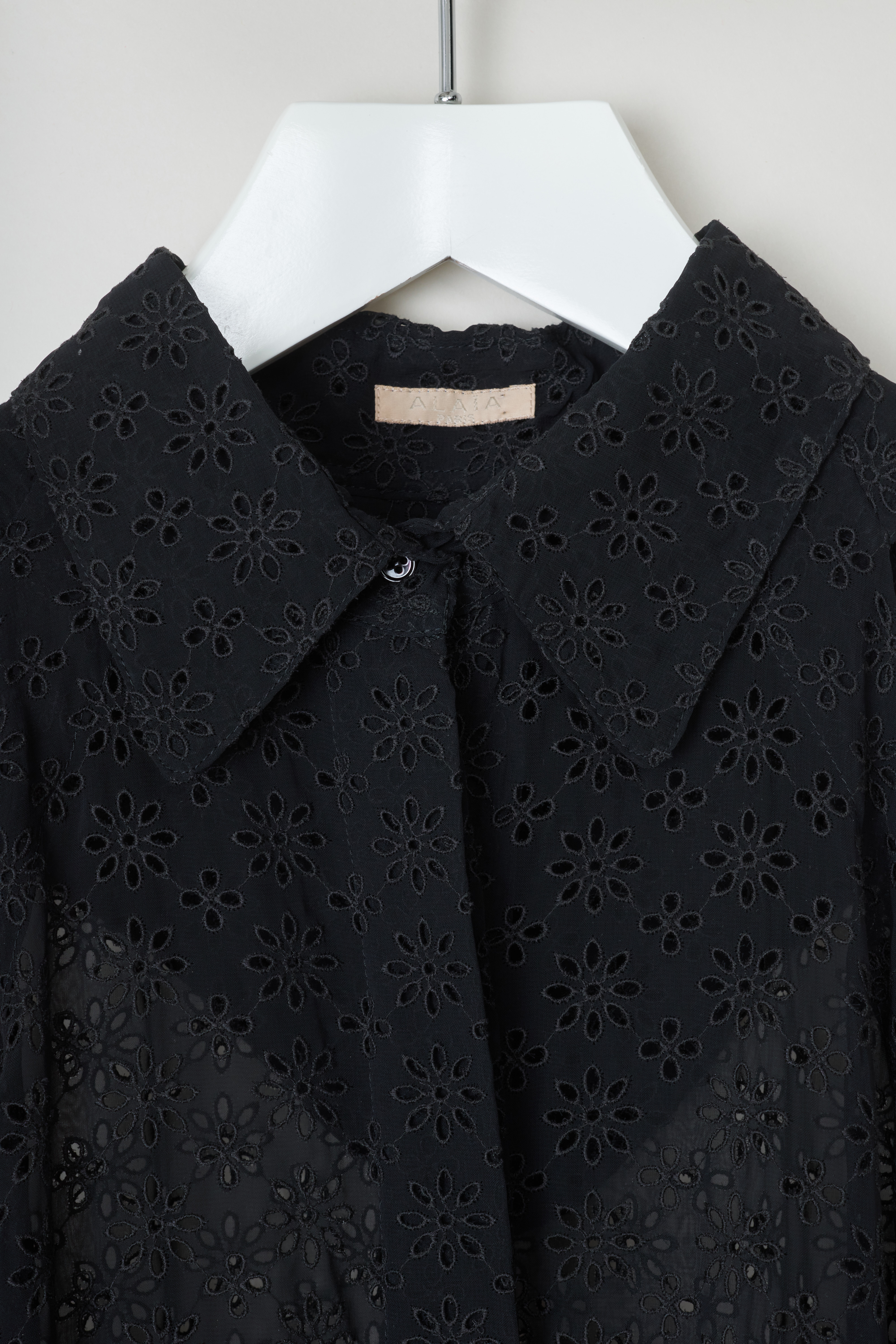 ALAÏA, Embroidered shirt dress, 10HPTBD4R296_robe_3_volants_099_noir, Black, Detail, This slightly see-through shirt dress with an embroidered floral motive. This dress features a pointed collar on the front, a small capelet detail in the back. A cord tunnel on waist can be used to cinch in the waist. 
