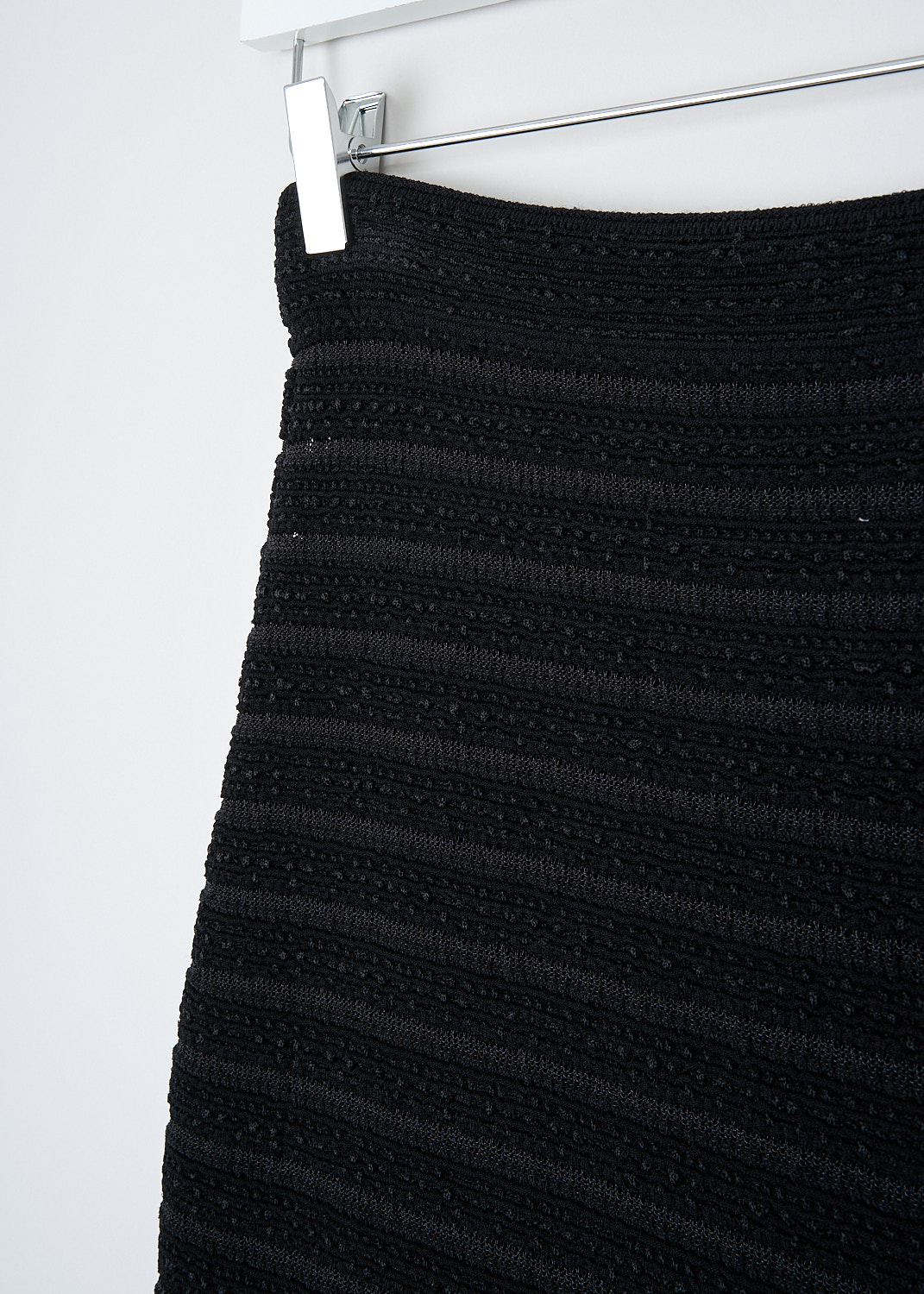 Alaïa, Black pencil skirt with horizontal stripes, 11CEMMAJ277_099_NOIR, Black, Detail, This black pencil skirt has a wider elasticated waistband. The skirt has a striped pattern alternating between see-through and solid stripes. The hem is rounded hemline in the front and a straight hemline in the back
