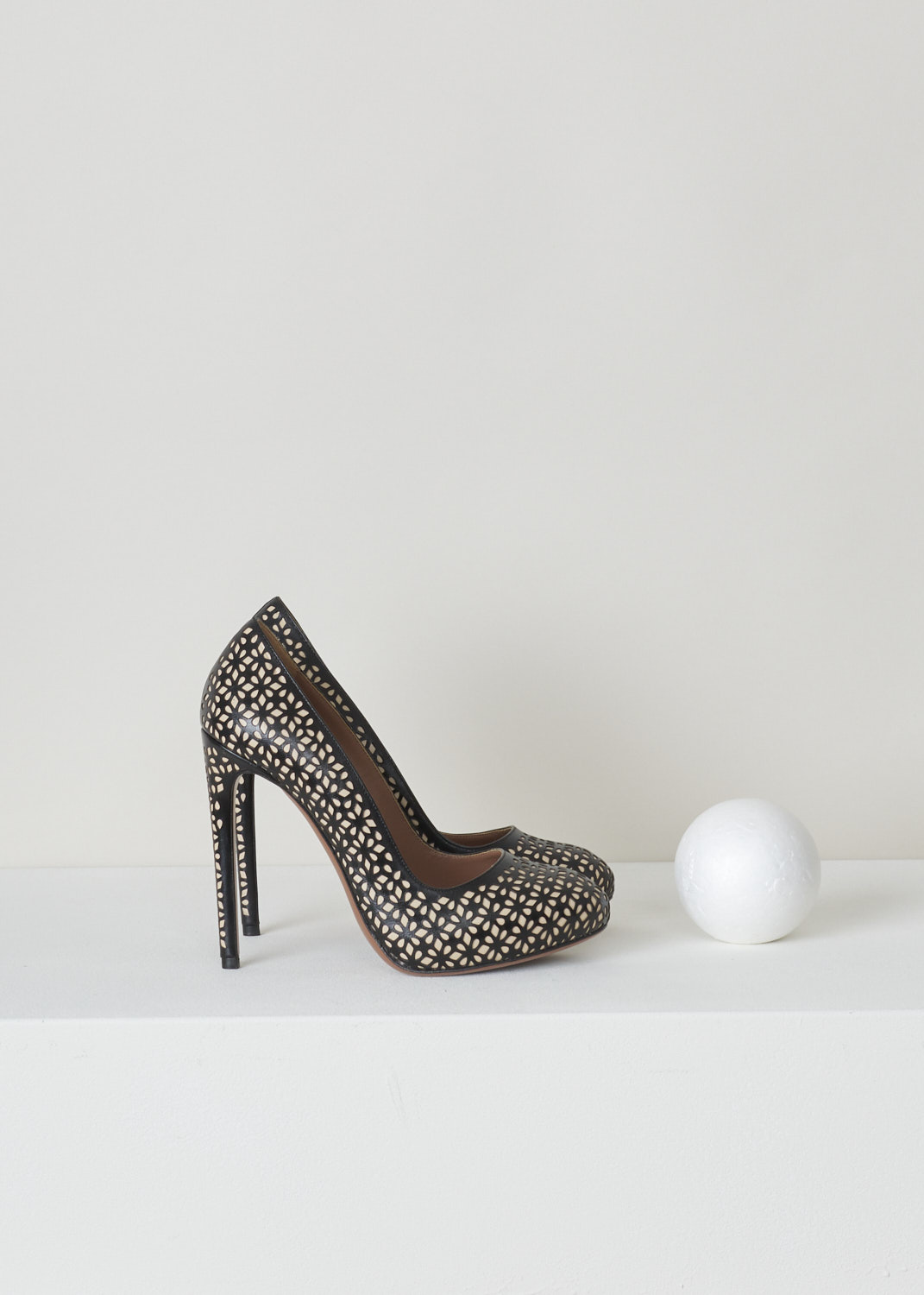 Alaïa, Black high heeled laser-cut pump, 3S2I013CE01_noir_roche_C950, black, side, Lovely high heel pumps comes in a two-tone colour palette, being the beige background colour which is adorned with this black signature laser-cut Vienne motif on top. Furthermore, this model has a rond nose and black trimmed topline. 

Heel height: 11 cm / 4.3 inch. 
