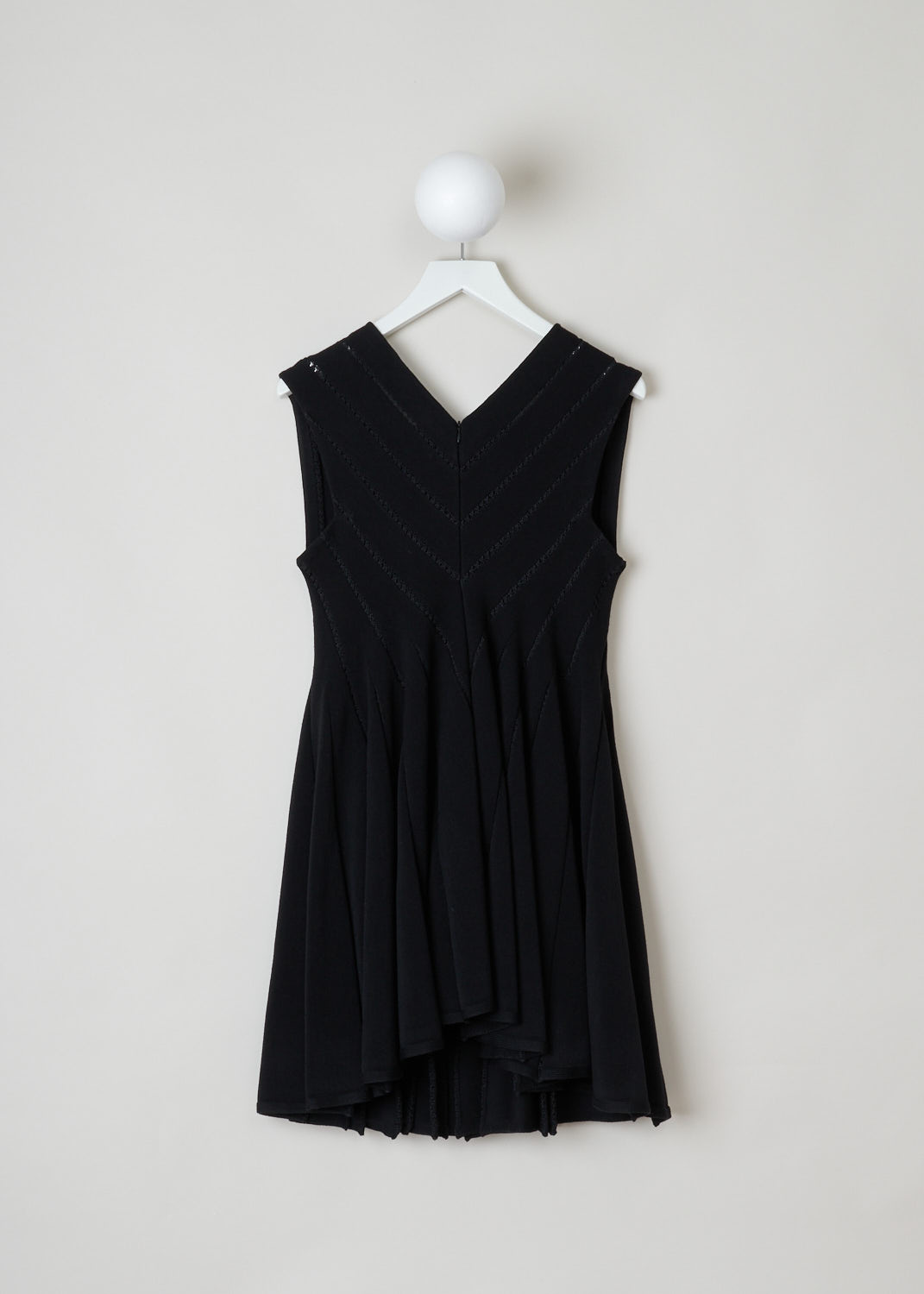 ALAÏA, Black embroidered babydoll dress, 4W9RB20CM120_baby_doll_SM_noir_C999, Black, Back, This black babydoll dress features a square cut neckline in the front and a V-shape in the back. The dress is put together in strips of fabric connected by black embroidery. The skirt is designed with knife pleats and flares out. The dress is thigh high. In the back, a concealed zipper functions as the closure.
