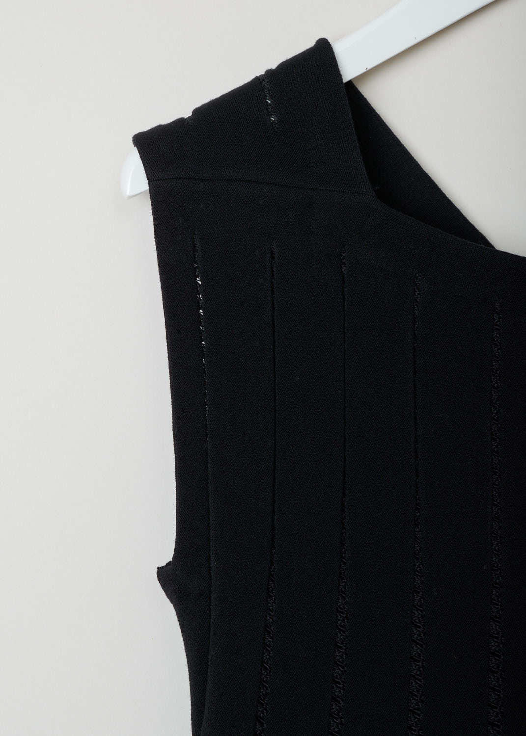 ALAÏA, Black embroidered babydoll dress, 4W9RB20CM120_baby_doll_SM_noir_C999, Black, Detail, This black babydoll dress features a square cut neckline in the front and a V-shape in the back. The dress is put together in strips of fabric connected by black embroidery. The skirt is designed with knife pleats and flares out. The dress is thigh high. In the back, a concealed zipper functions as the closure.
