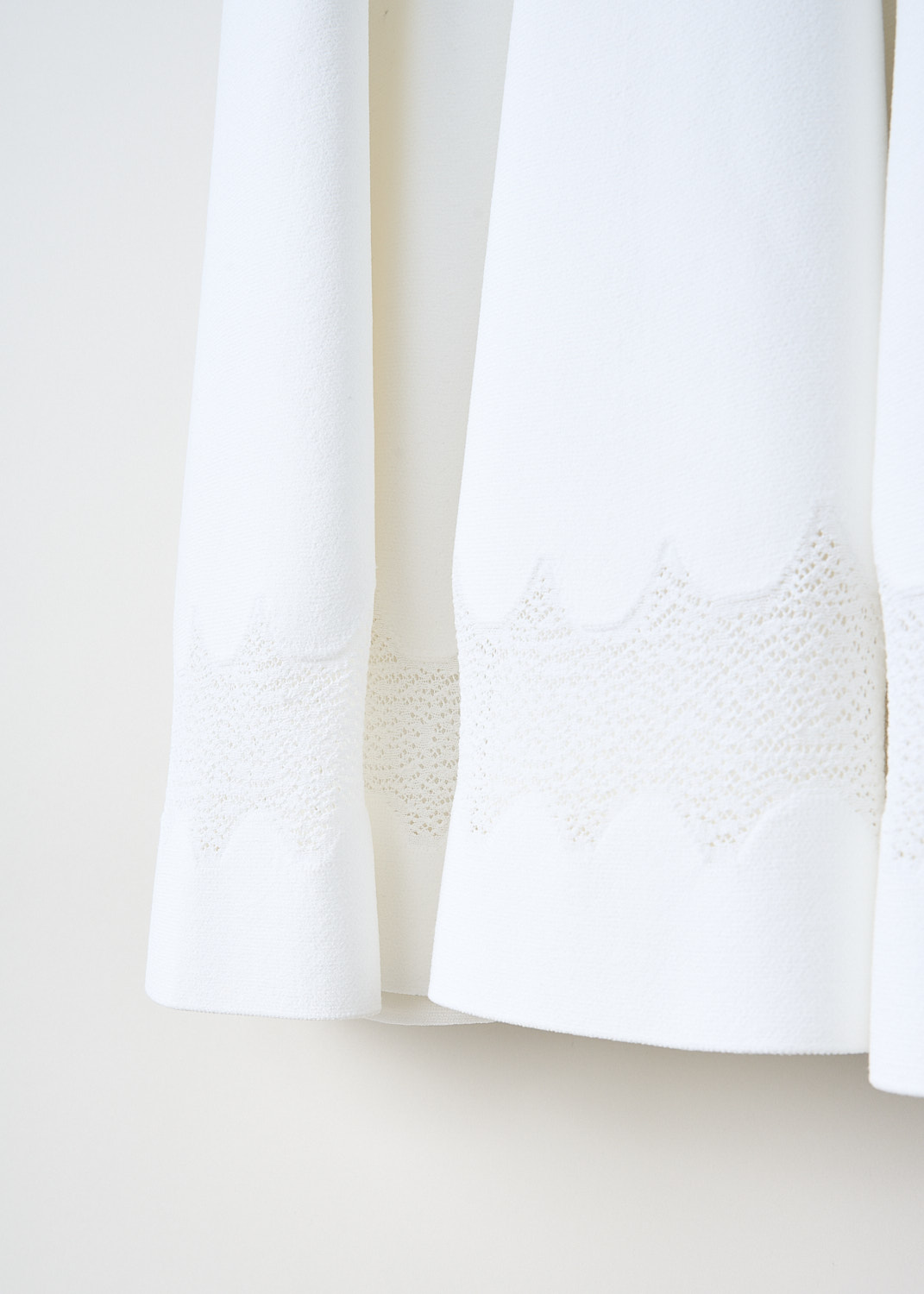 Alaïa, White sleeveless dress with zigzag pattern, 5E9RC96RM164_ROBE_NUAGES_BLANC, White, Detail 1, This white sleeveless dress has a round neckline. Three horizontal mesh zigzag inserts go all the way around. The dress has a fit-and-flare silhouette. In the back, a centre zip functions as the closure.
