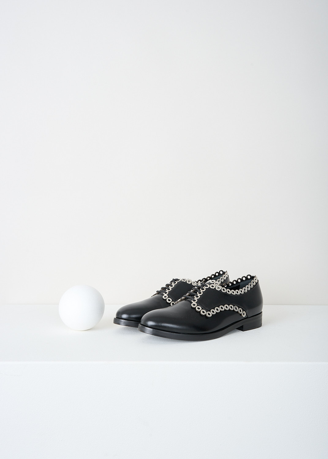 Alaïa, Black derby shoes with silver detailing, 6W3D064CG19_C999_NOIR, Black, Front, These black leather derby shoes have a round toe, a classic lace-up closing with black laces and a small heel. Silver-toned rings run along the seams.

