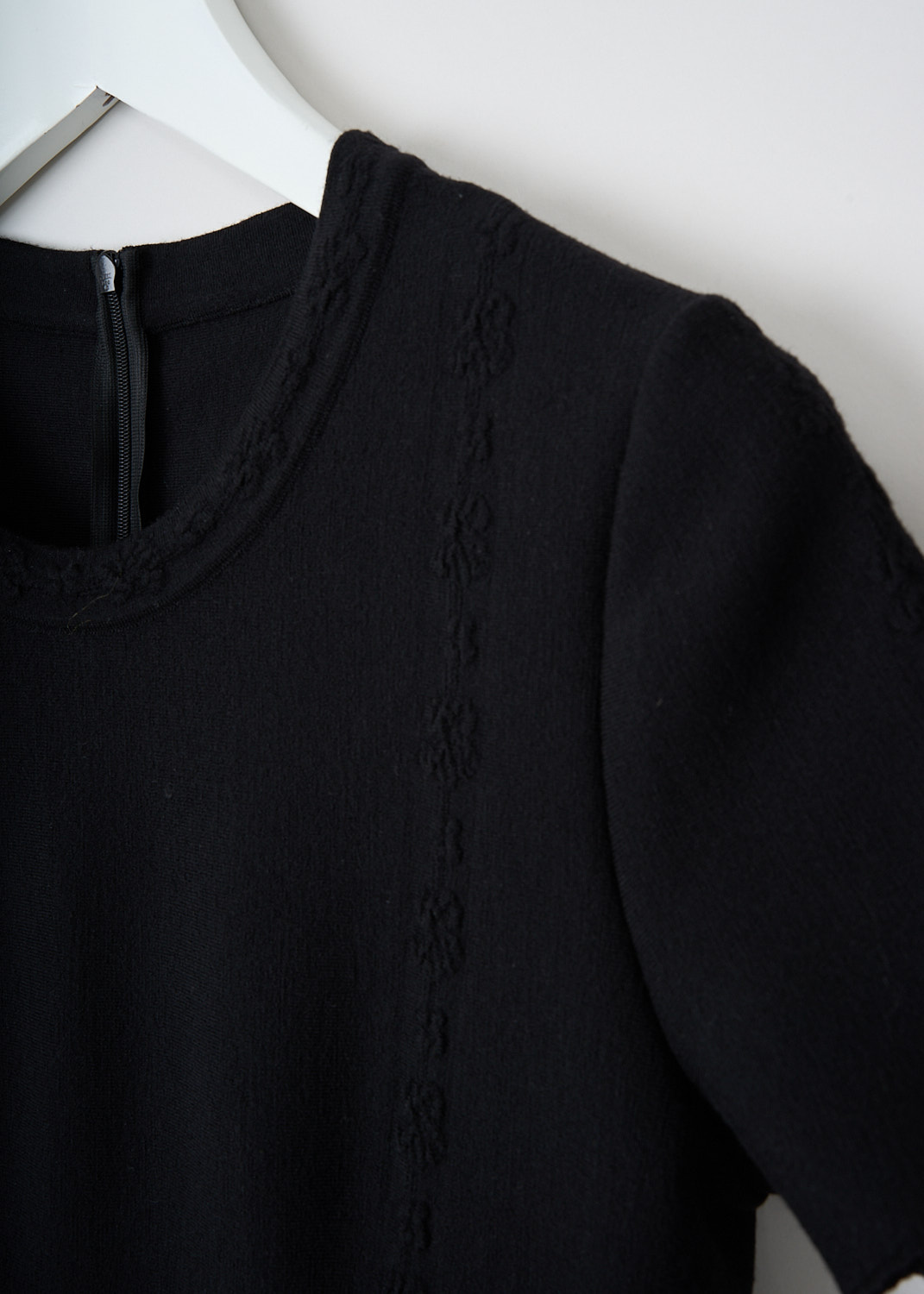 Alaïa, Black fitted maxi dress, 7H9RJ63LM364_C999_NOIR, Black, Detail, This black fitted maxi dress has a round neckline and short sleeves. The dress has a fitted bodice and a flared pleated midi skirt . On the neckline, sleeves and along the front, subtle floral trims can be found. In the back, a concealed centre zip functions as the closure.
