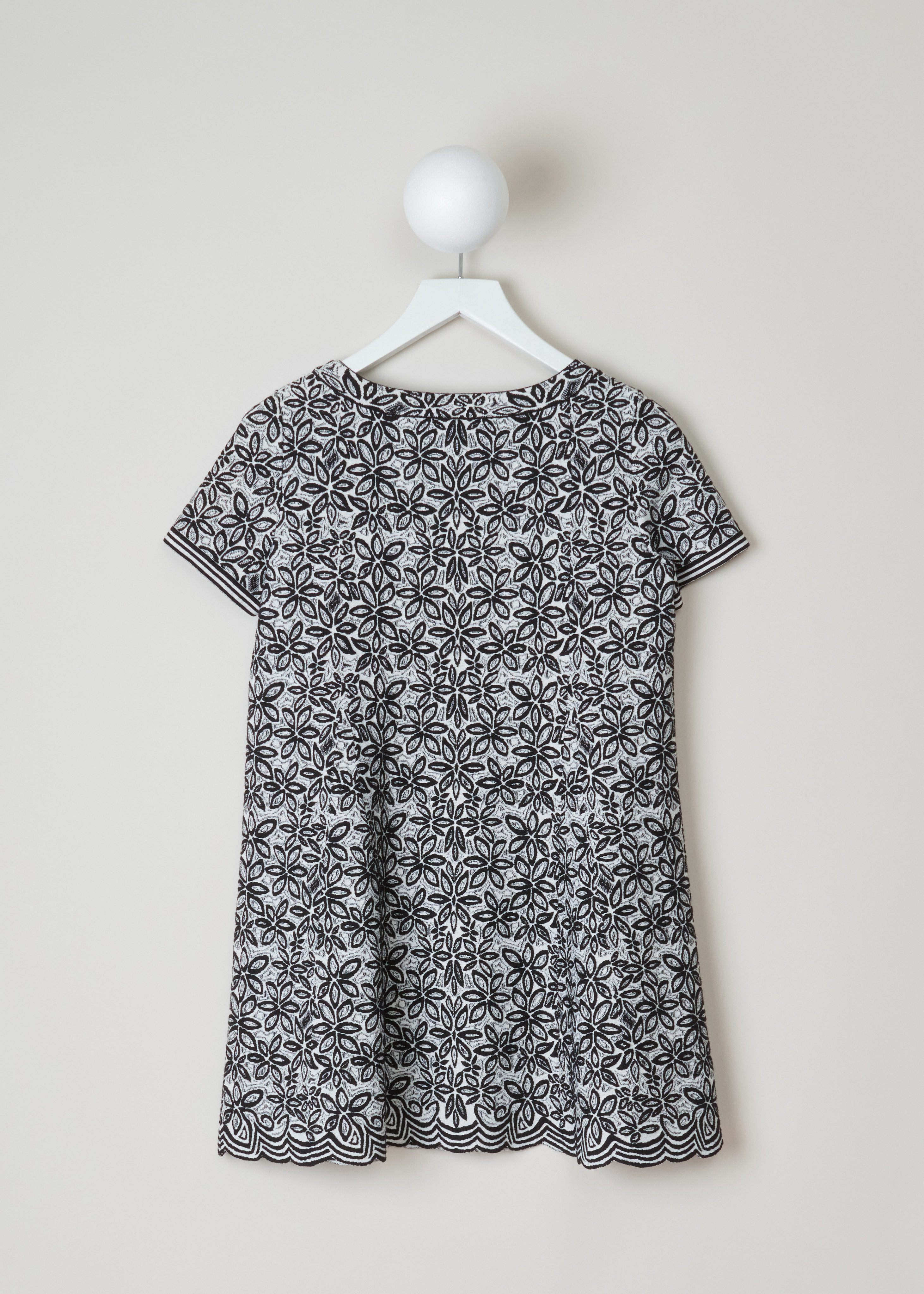 ALAÏA, Wool-blend tunic with a flower pattern, 7W9UE52RM353_TUNIQUE_ADENIUM_C009_Blanc/Noir, Grey, Print, Back, Jacquard knitted tunic with a black-and-white flower motif. The dress has short sleeves, a wide round neckline, an A-line silhouette and scalloped hems.

