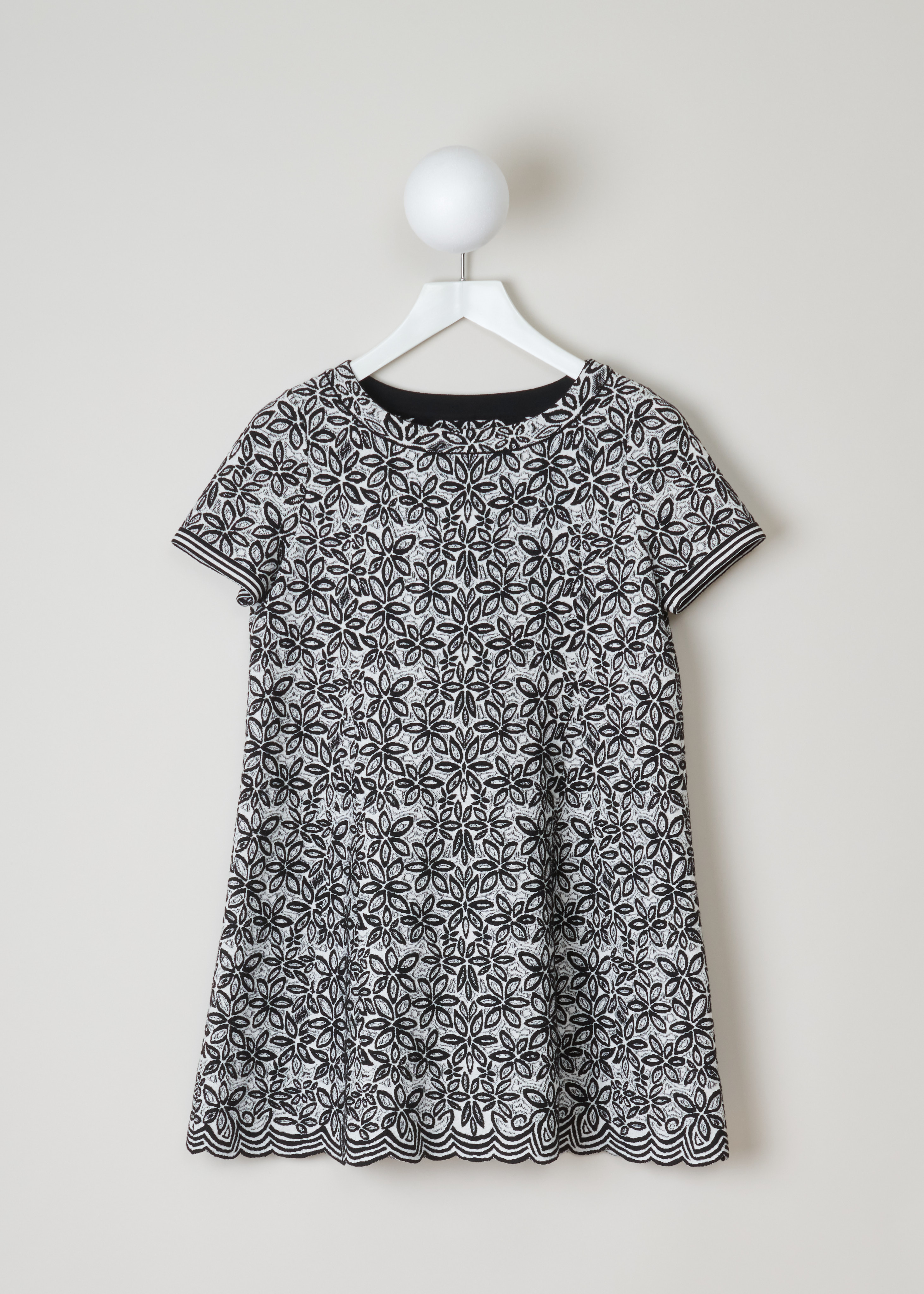 ALAÏA, Wool-blend tunic with a flower pattern, 7W9UE52RM353_TUNIQUE_ADENIUM_C009_Blanc/Noir, Grey, Print, Front, Jacquard knitted tunic with a black-and-white flower motif. The dress has short sleeves, a wide round neckline, an A-line silhouette and scalloped hems.

