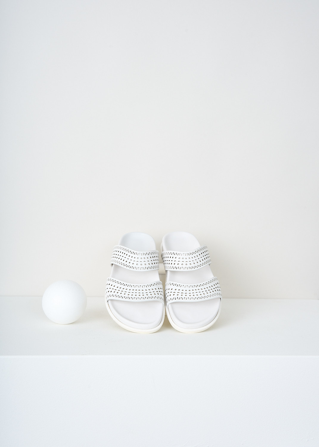 Alaïa, White leather slides with laser-cut straps, AA3M022CK035_006_BLANC_CRAIE, White, Top, These white leather slides have two laser-cut straps.
