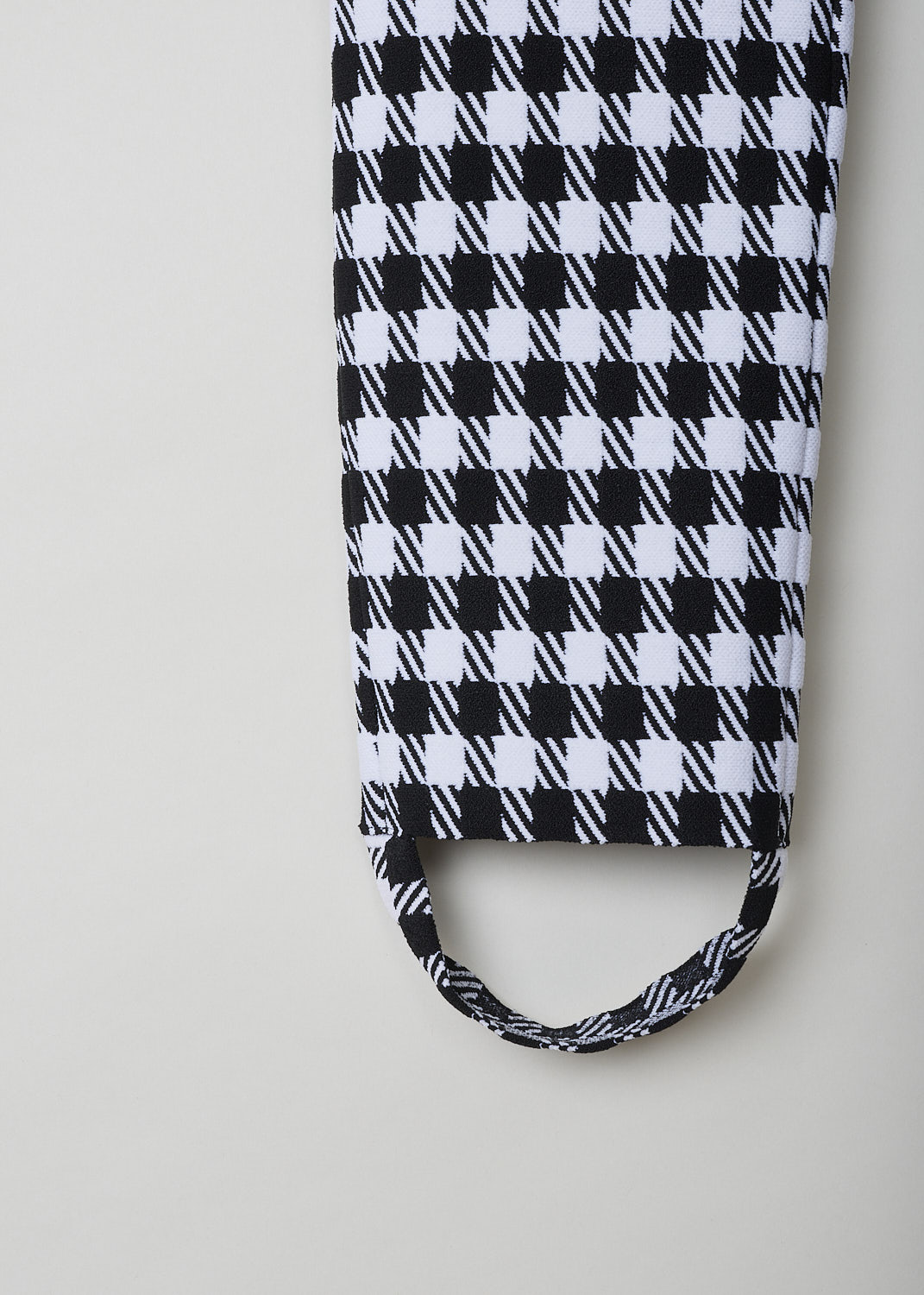 ALAÏA, BLACK-AND-WHITE HOUNDSTOOTH STIRRUP PANTS, AA9B10322M710_HOUNDSTOOTH, Black, White, Print. Detail, These close-fitting stirrup pants have a magnified black-and-white Houndstooth print throughout. These pants are high-waisted. The tapered pant legs extend into straps, that are worn under the arch of the foot to hold the pant leg in place. These slip-on pants are fully elasticated. 