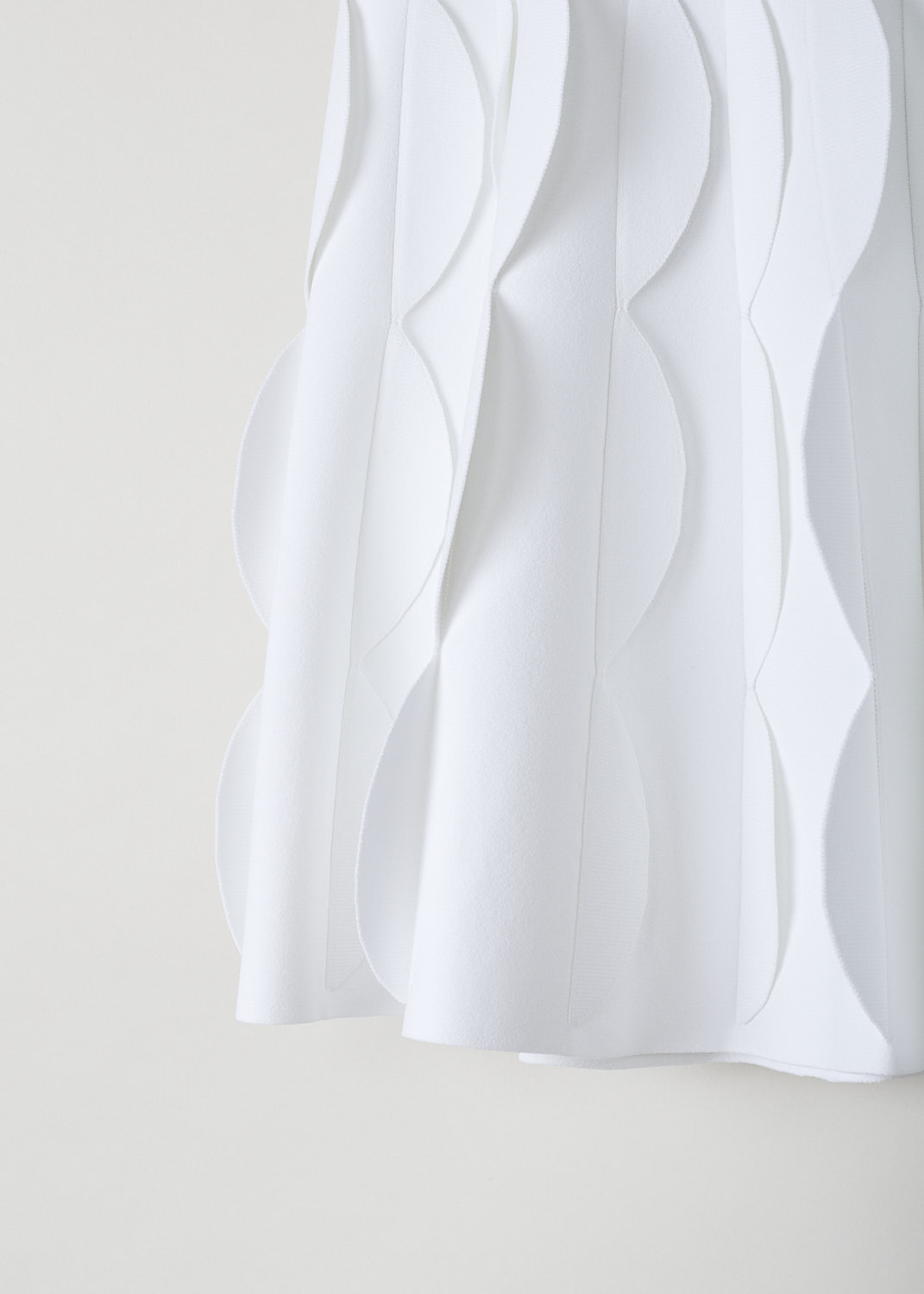 ALAÃA, WHITE SCALLOPED MINI SKIRT, AA9J2051CM609_JUPE_COURTE_BLANC, White, Detail, This white A-line mini skirt has a broad waistline with a scalloped outer edge. The skirt flares out into scalloped pleats throughout. 
