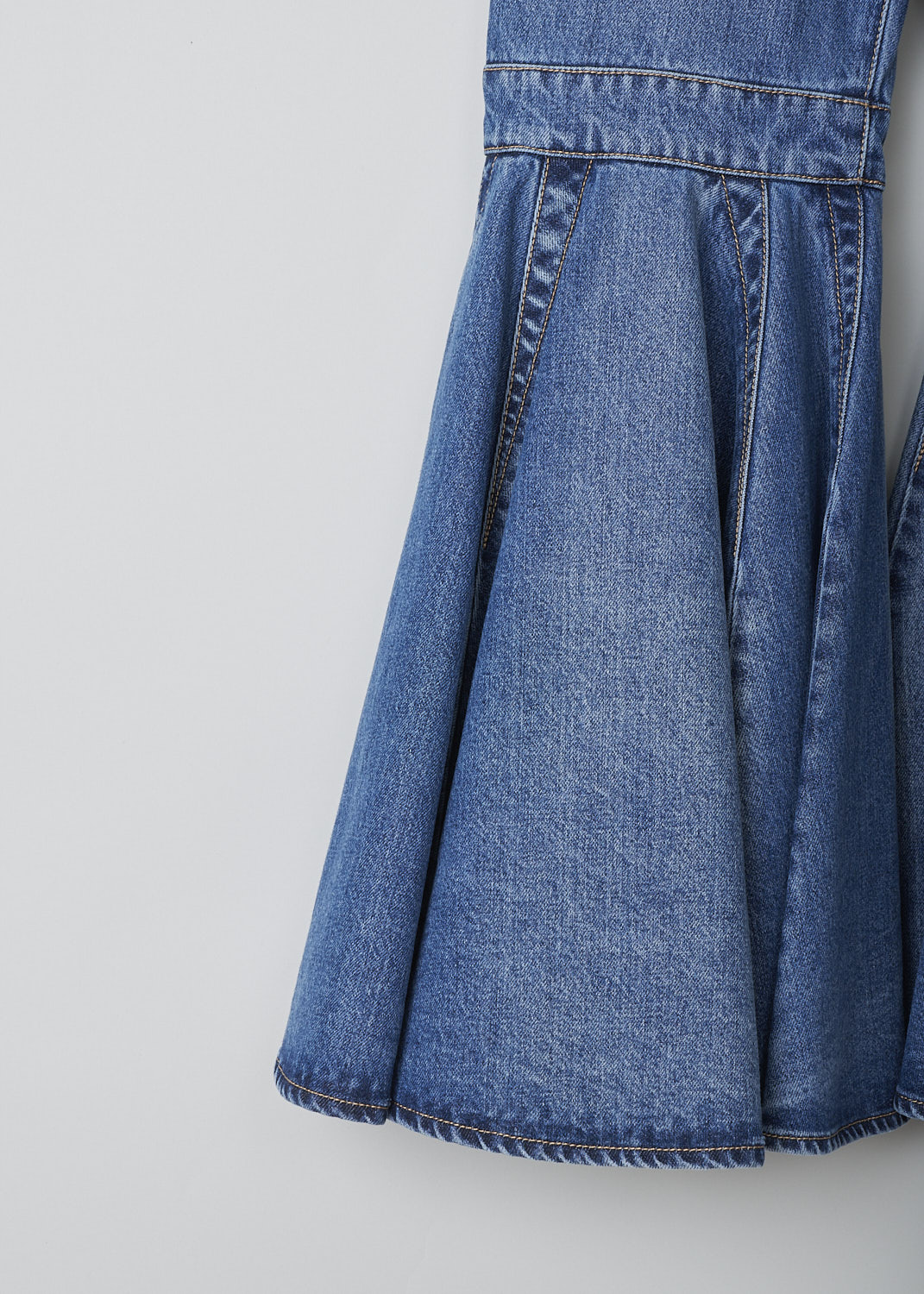 ALAÏA,FLARED BLUE DENIM JEANS, AA9P01032T441_CRINOLINE_JEANS, Blue, Detail 1, These high-waisted flared blue denim jeans are fitted to the knee before flaring out in a 70's flounce. These jeans have belt loops, a front button and zip closure and slanted pockets. In the back, these pants have patch pockets and decorative seams. 

