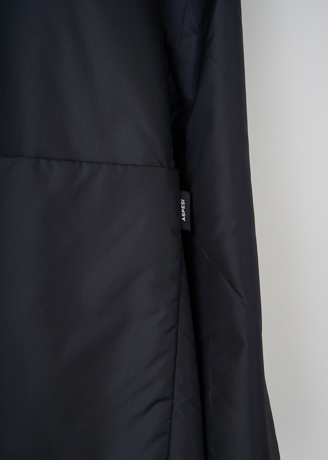 Detail of Aspesi black padded jacket with notched lapel and padded texture at Kiki's Stocksale Maastricht designer outlet.