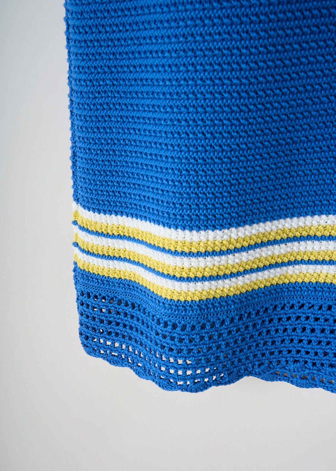 B.B. Wallace Reinhardt blue crochet dress featuring contrasting yellow-and-white stripes and scalloped hem, luxury designer fashion at Kiki Niesten Maastricht