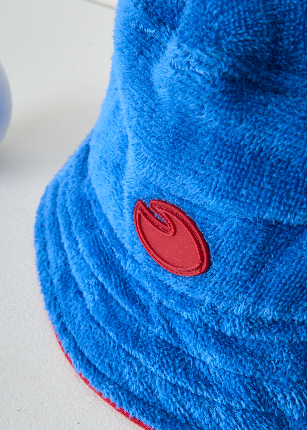 Baindoux blue terrycloth bucket hat detail featuring the brand’s red logo, crafted from soft 100% Giza cotton, luxury designer accessory at Kiki’s Stocksale