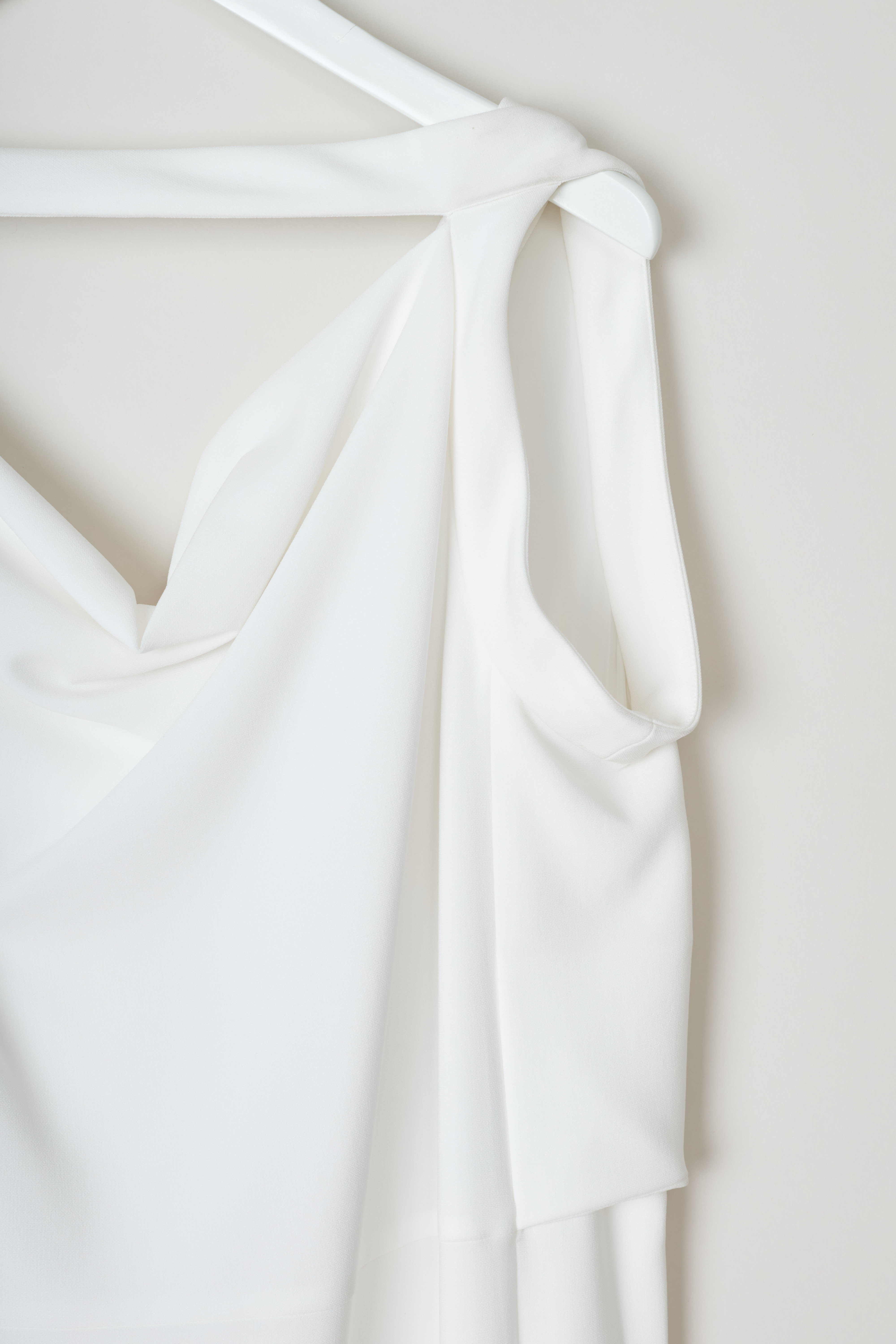 Balenciaga, Shift dress with an cowl neckline, 293704_TBDI6_9800_white, white, detail. Shift dress with a draped neckline plus ribbon on the front and an open back. Furthermore a decorative ribbon can be found on the back, which either can be tied on the back, or wrapped around to the front and tied there. Concealed pockets can be found on the front. 