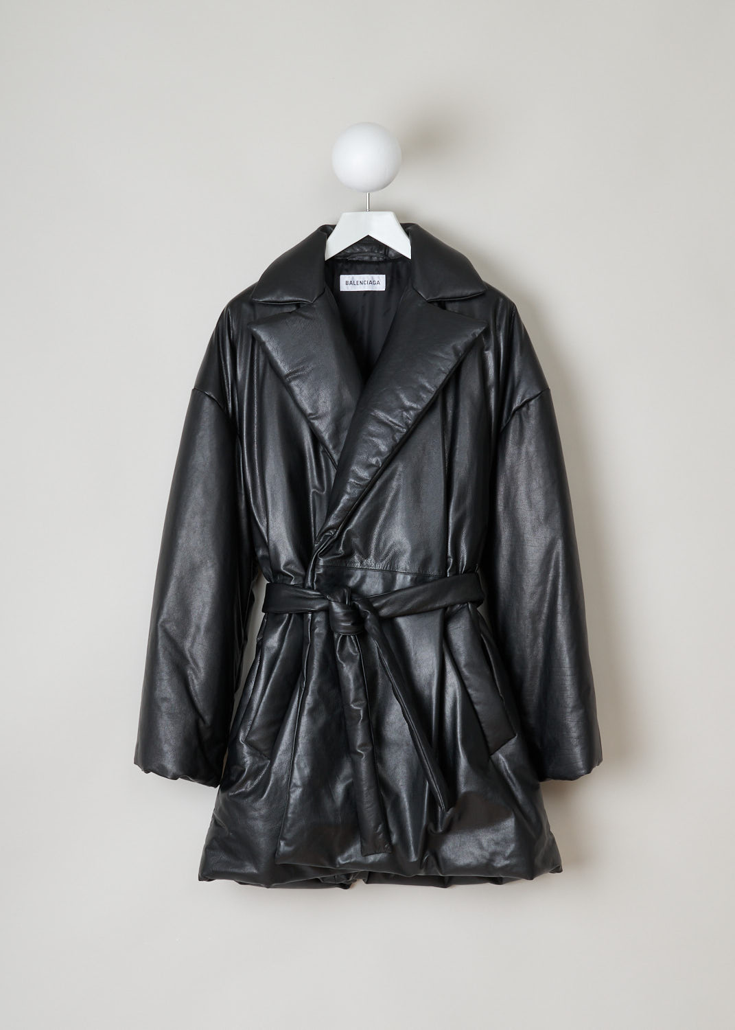 Balenciaga, Black lined leather coat, 583549_TFS06_1000, black, front. Lovely black quilted, calfskin coat made by true craftsmen. Featuring a collar that leads into the notched lapel, which leads into the fastening option being, waist-tie ribbon made from the same fabric. Comes with dropped shoulders and long sleeves. Furthermore two welt pocket can be found on the front and two more slip-in pockets on the inside.  