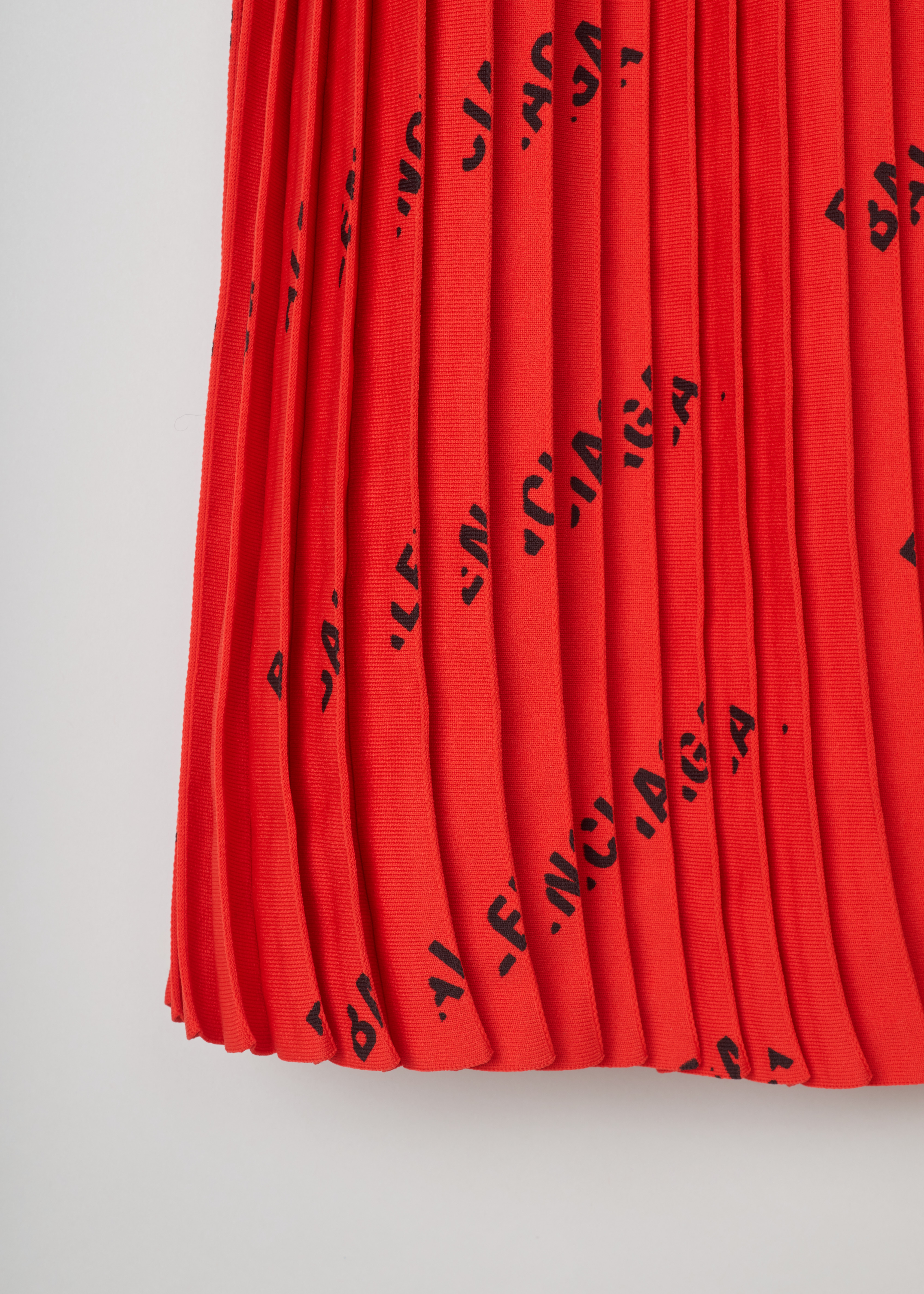 Balenciaga Plissé skirt with logo pattern 570845_T6140_6282 red detail. Midi length plissé skirt with an all over logo print of the Balenciaga logo and an elasticated waistband.