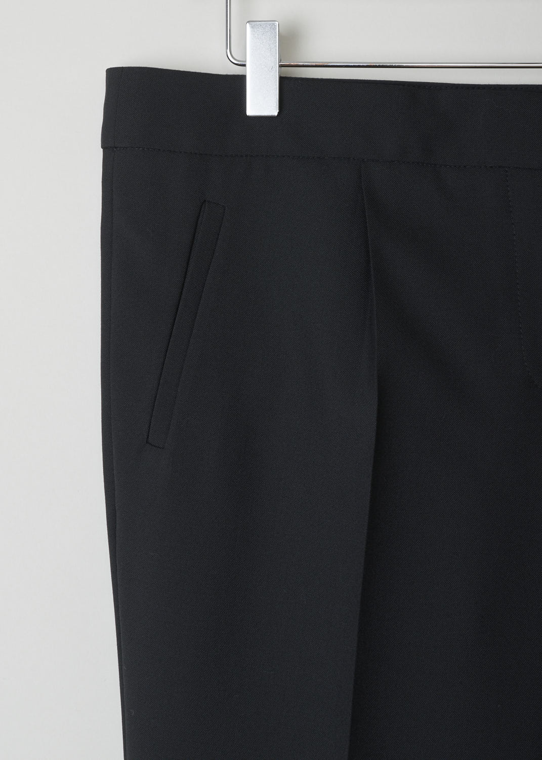 BALENCIAGA, CLASSIC BLACK PANTS WITH SUBTLE ZIPPER DETAIL, 329181_TCJ69_1000, Black, Detail, This classic black pants has front creases along the length of the legs. These same creases can also be found on the back of the legs. On the front, welt pockets can be found on either side. On the ends of the legs, concealed zippers can be found that open to about ankle height.

