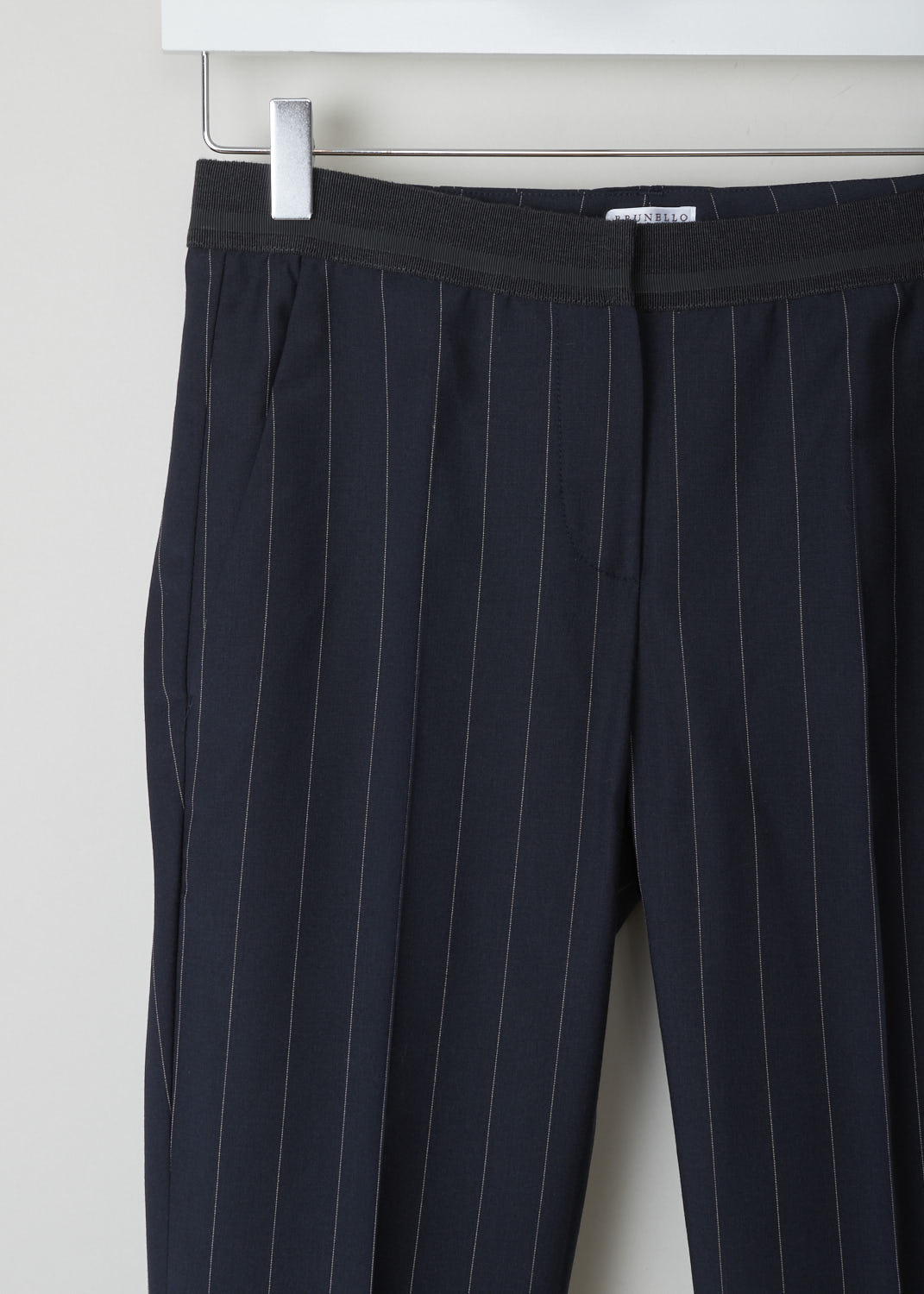 BRUNELLO CUCINELLI, NAVY BLUE TROUSERS WITH PINSTRIPE, M0H35P1500_C6009, Blue, Detail, These navy blue pinstripe trousers are made of a wool blend. Featuring a partly elasticated waistline, forward slanted pockets in the front, and two buttoned welt pockets in the back. Along the length of the pant leg, centre creases can be found. These trousers have a folded hem.
