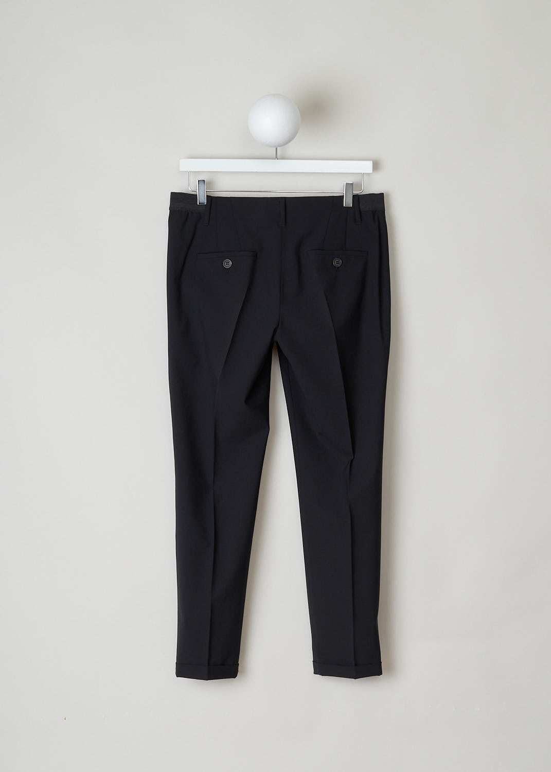 BRUNELLO CUCINELLI, BLACK PANTS WITH PARTLY ELASTICATED WAISTBAND, M0W07P1500_CD531, Black, Back, These black pants have a partly elasticated ribbed waistline with with a decorative horizontal stripe. These pants have two belt loops on the backside. A concealed clasp and zipper function as the closing option. The pants have forward slanted pockets in the front and two buttoned welt pockets in the back.The tapered pant legs have centre creases. These pants have a folded hem.
