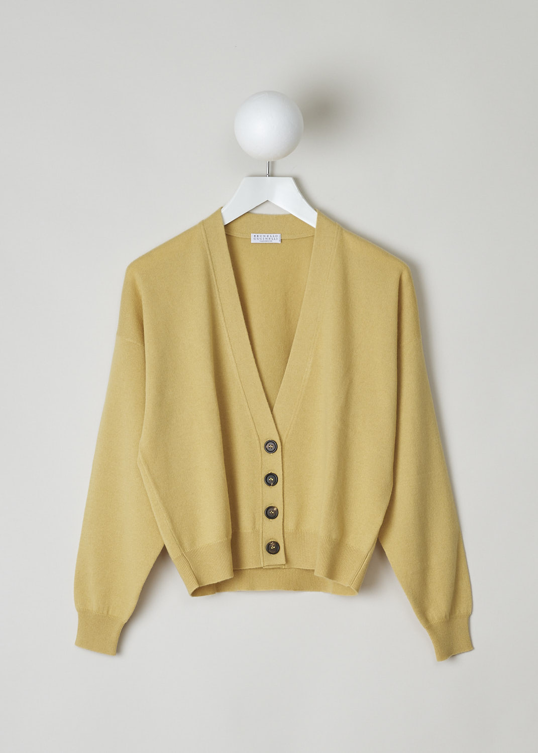 BRUNELLO CUCINELLI, YELLOW V-NECK CARDIGAN, M12170206_C2991,Yellow, Front, Yellow cardigan with a subtle monilli beaded trim in the back of the neck. The cardigan has a V-neckline, front button closure with tortoise shell buttons and a ribbed hemline and cuffs. The cardigan has a cropped length. 
