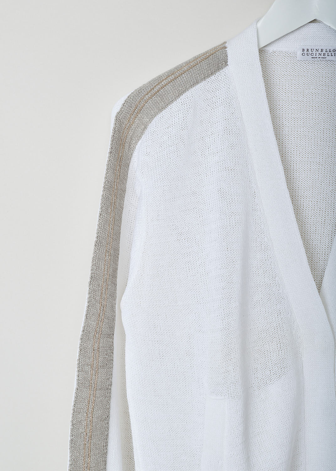 Brunello Cucinelli, Loosely-woven white cardigan, M78762906_C159, White, Detail, This loosely-woven white cardigan has a V-neckline and a concealed press button closure. The long sleeves have monili-decorated beige trims from shoulder to cuff. The cardigan has two slip pockets. 
