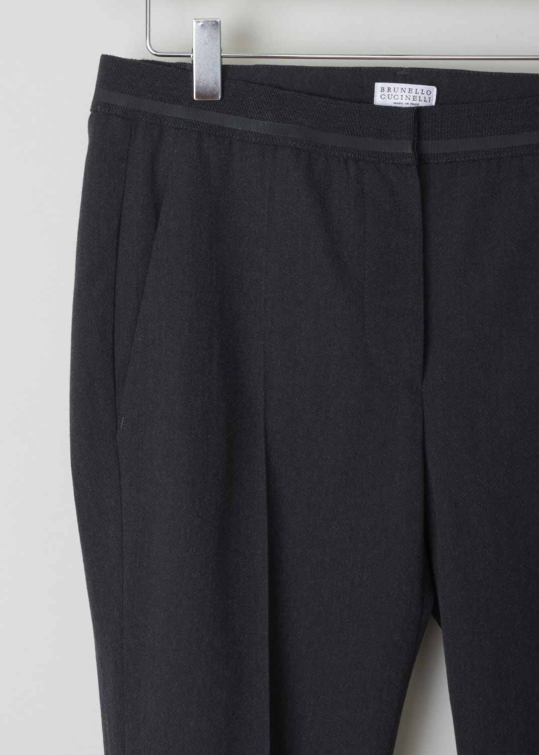 BRUNELLO CUCINELLI, DARK GREY PANTS WITH PARTIALLY ELASTICATED WAISTBAND, MA051P1500_CB415, Grey, Detail, Dark grey pants with partly elasticated waistline. A clasp and zipper function as the closing option. These pants feature forward slanted pockets in the front, and two buttoned welt pockets in the back. Along the length of the pant leg, centre creases can be found. These pants have a folded hem.
