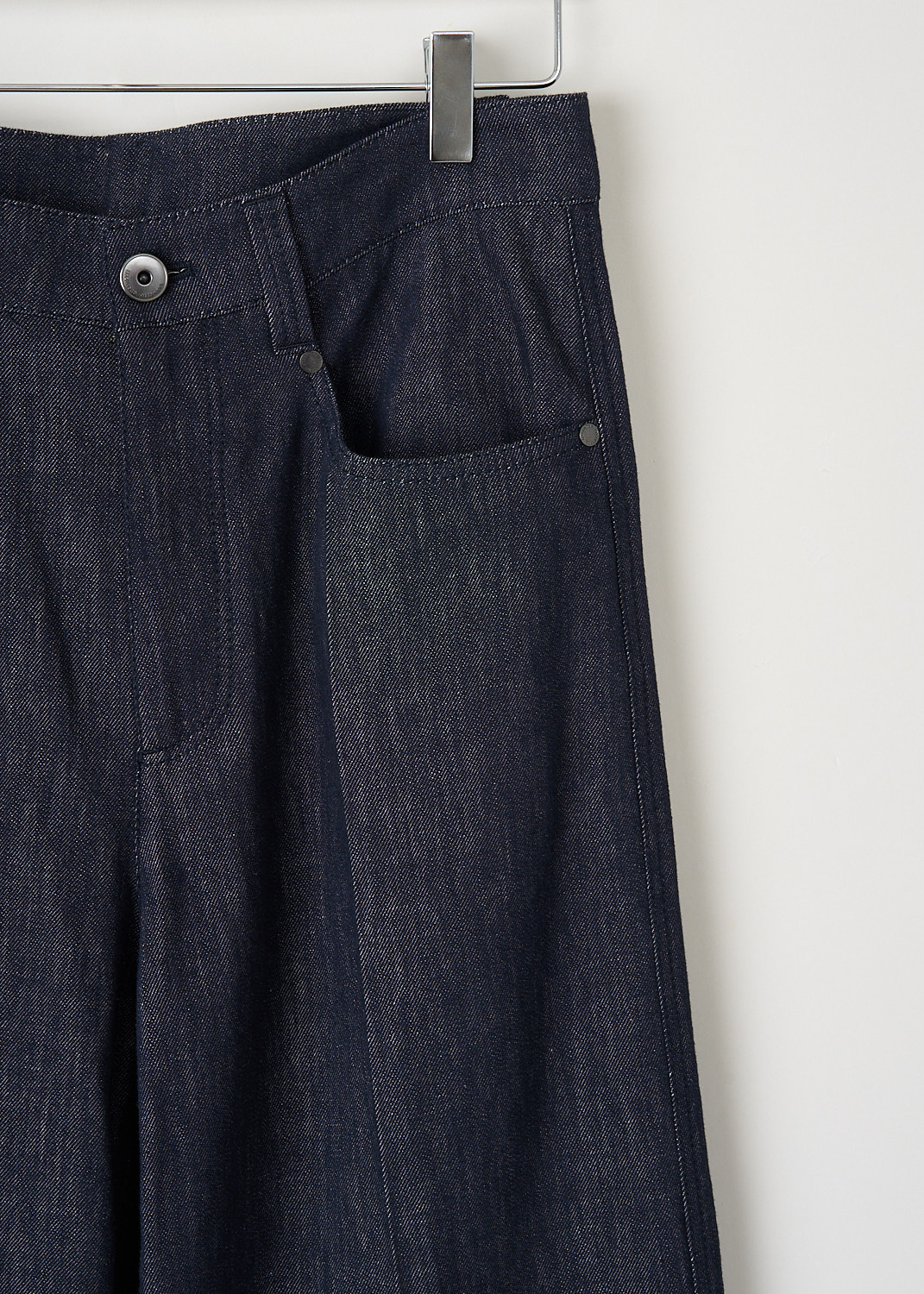 Close-up of the dark blue Brunello Cucinelli denim trousers highlighting the waistband, belt loops and refined button-and-zip fastening – high-end designer item at Kiki’s Stocksale.