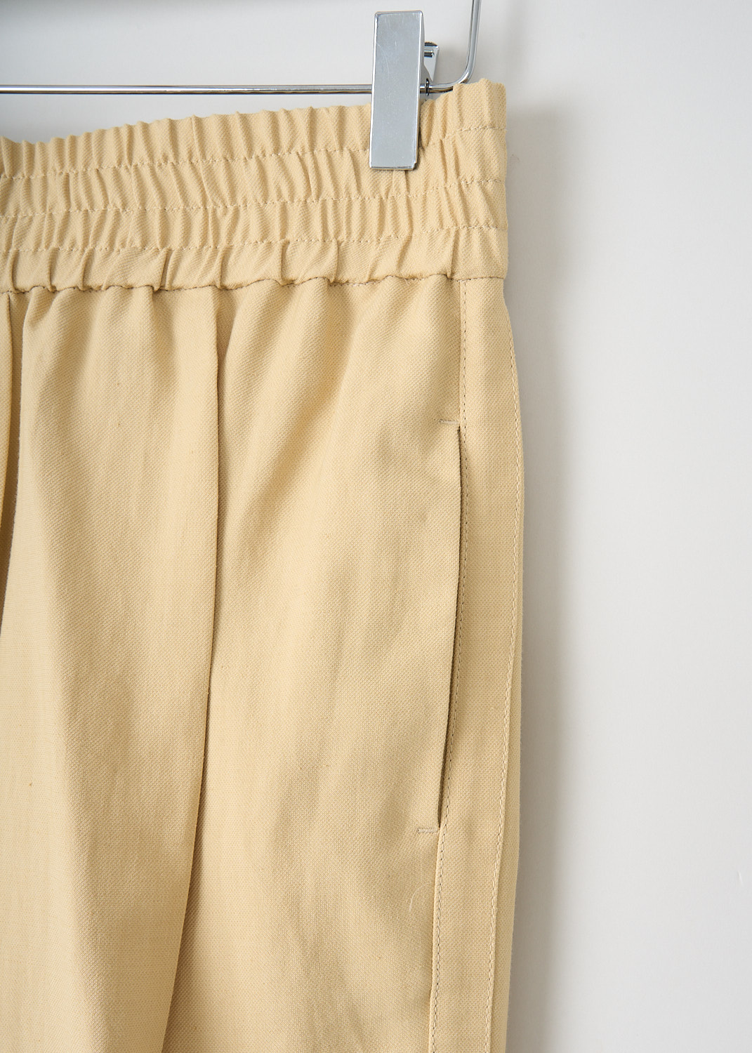 Brunello Cucinelli, Pale yellow jogger-style pants, MH126P7197_C8612, Yellow, Detail, These pale yellow jogger-style pants have an elasticated waistband. These pants have slanted pockets in the front and welt pockets in the back. The straight pant legs have pressed creases. Along the sides, broad trims in the same fabric run along the pant legs. 
