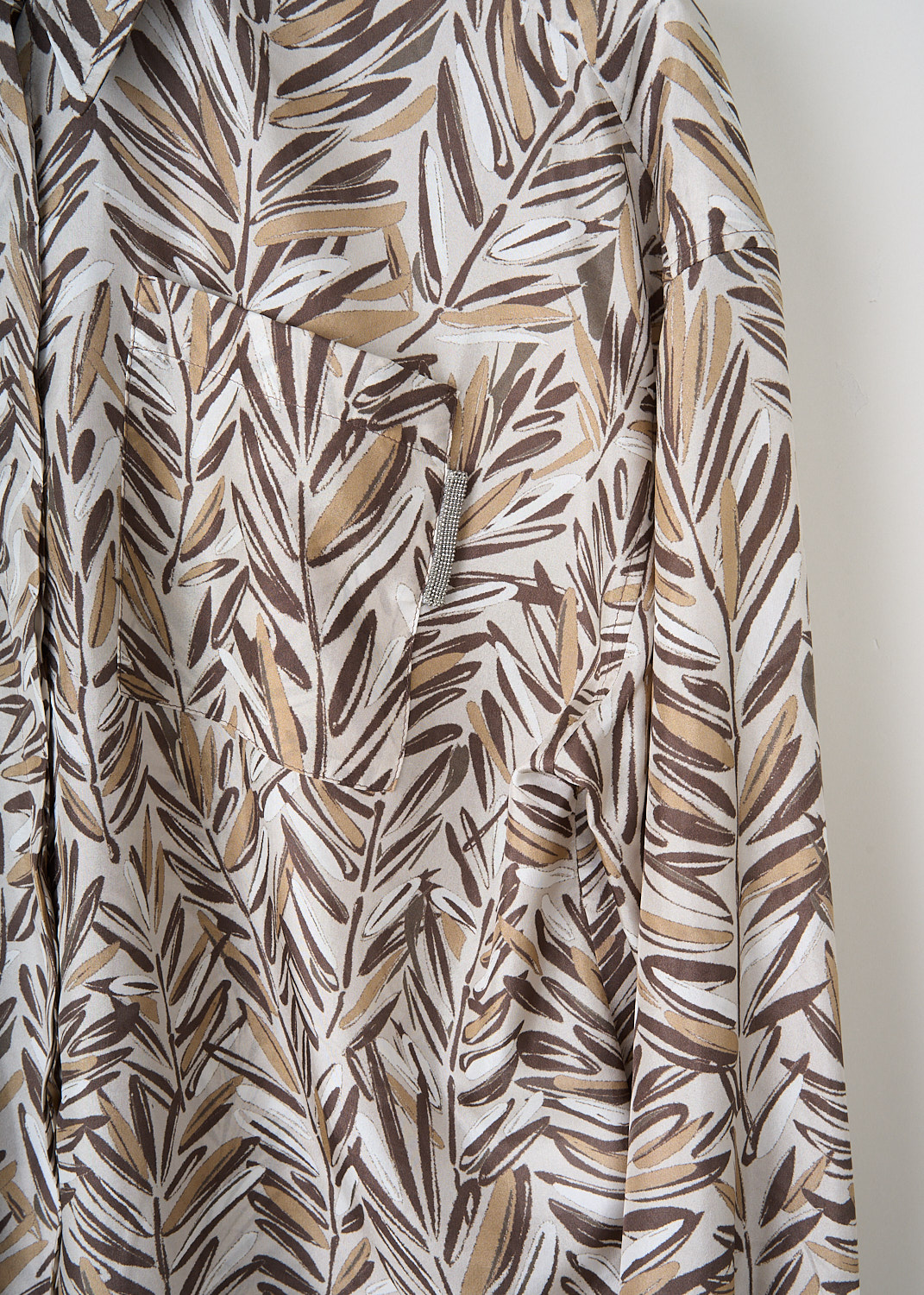 Close-up of Brunello Cucinelli blouse showing beige and brown silk print and monili embellishment on the breast pocket.