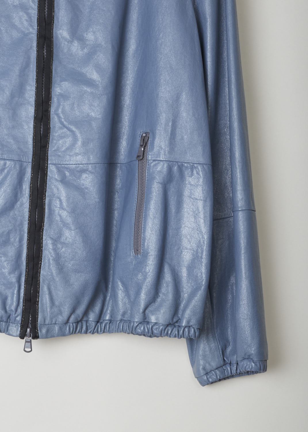 BRUNELLO CUCINELLI, HOODED LEATHER JACKET WITH EMBELLISHMENTS, MPBIS8276_C6173, Blue, Grey, Detail 1, This sporty leather jacket features a hood with a subtle bejeweled trim that extends down along the zipper. The cuffs and the hem have an elastic band, cinching them in. Two welt pockets with zippers can be found on the front of the jacket. 
