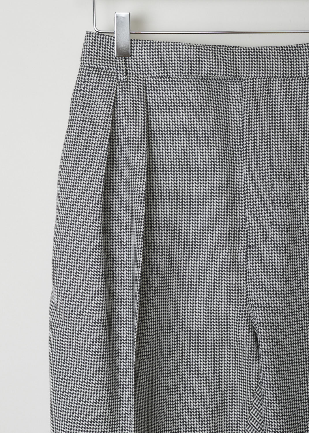 CELINE, HOUNDSTOOTH TROUSERS WITH FRONT PLEATS, 026D_2P106_18BN, Print, Black, White, Detail, Black and white Houndstooth trousers. These trousers have a concealed clasp and zipper closure. Slanted pockets can be found on either side. Front pleats decorate the tapered pant legs. In the back, two buttoned welt pockets can be found.
