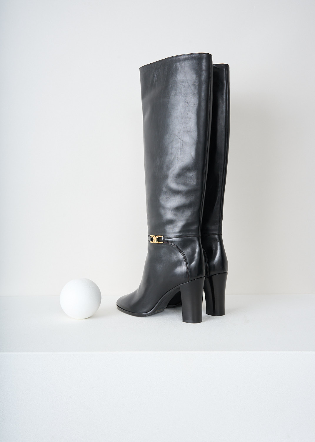 Back view of the black leather knee-high boots with stacked block heel by Celine, available at designer boutique Kiki's Stocksale in Maastricht.