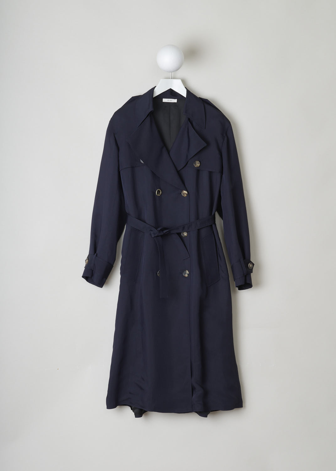 CÃ‰LINE, MIDNIGHT BLUE RAINCOAT, 6464_28U36_0MI_C01, Blue, Front, Elegant midnight blue trench coat. The coat has a notched lapel and classic details such as epaulets and storm flaps. Two rows of buttons form the closing option. The coat comes with a matching belt to cinch in the waist. The long sleeves have sleeve straps on the cuffs. A slanted pocket can be found on either side. In the back, the coat has a centre slit.