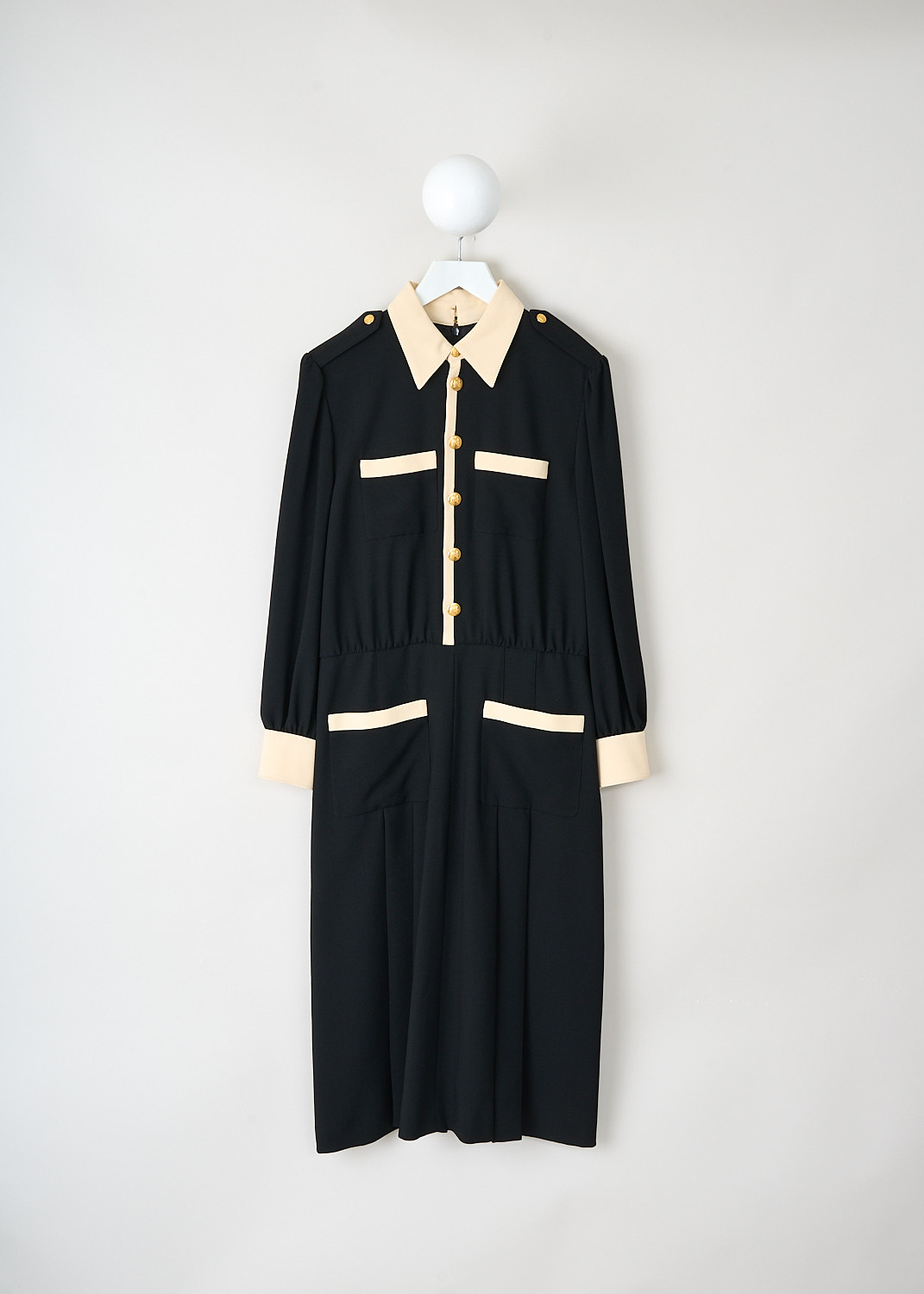 Celine black midi dress with contrasting ivory details, pointed collar, gold-tone button front closure and pleated skirt, available at Kiki’s Stocksale designer outlet Maastricht.