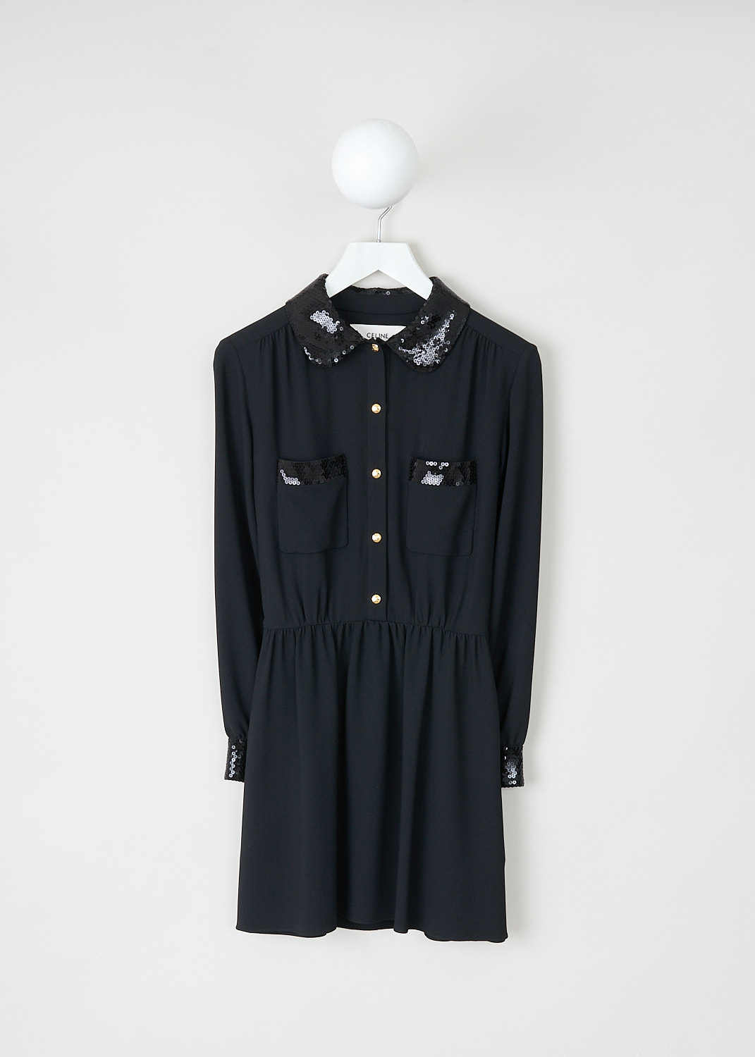 Celine, Black dress with sequins detailing, 2R25K_865C_38NO, Black, Front, This black mini dress features a sequin-clad Claudine collar and a partial front button closure with gold-tone buttons. The long sleeves are finished with sequin-clad cuffs. On the bodice, there are two patch pockets accented with broad sequin trim. The dress has a flared skirt.

