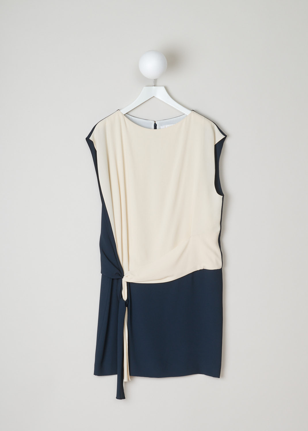 ChloÃ©, Dropped waist dress in beige and blue, 15SRO18_15S238_1Z7_black_navy_vanilla, blue beige, front. Dropped waist dress, sharing some similarities with a wrap dress. The blue and beige wrap ribbon can be tied into various knots. Furthermore, this sleeveless model has a round neckline and a concealed zipper with a metal clip on the back. 