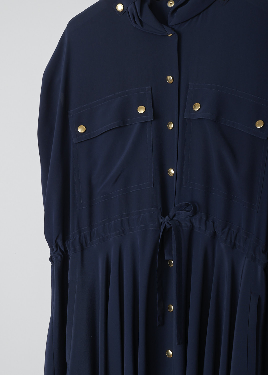 CHLOÃ‰, INK NAVY DRESS WITH GOLD-TONE BUTTONS, CHC19SRO510044C3_INK_NAVY, Blue, Detail 1, This Ink navy silk maxi dress has gold-tone snap buttons throughout. The dress has a gathered collar with snap buttons and a front snap button closure. The wide long sleeves can be rolled up with snap buttons. On the front, the dress has two buttoned patch pockets and slanted pockets. A drawstring can be used to cinch in the waist. The dress has an asymmetric hemline.    
