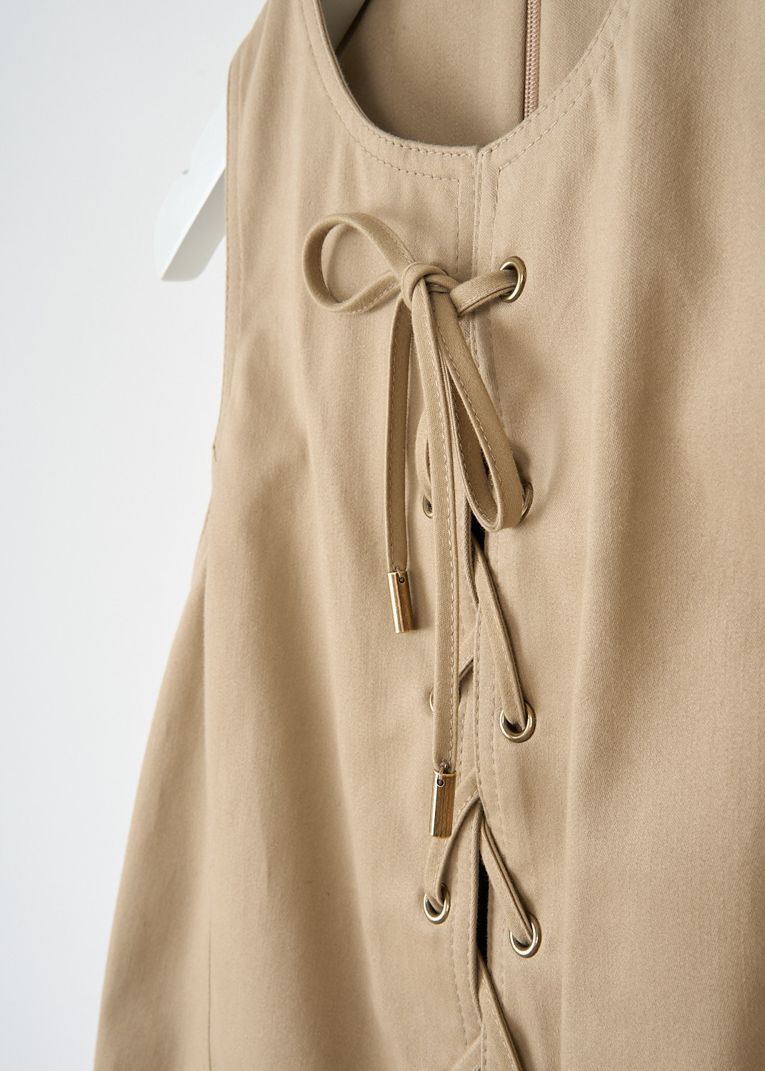 Chloé, Sleeveless mini dress in Argil brown, CHC25SRO36339_20G_ARGIL_BROWN, Brown, Detail, This sleeveless mini dress in Argil brown has a round neckline and a front lace-up detail. On the front, the dress has two flap patch pockets. In the back, a concealed centre zip functions as thee closure. 