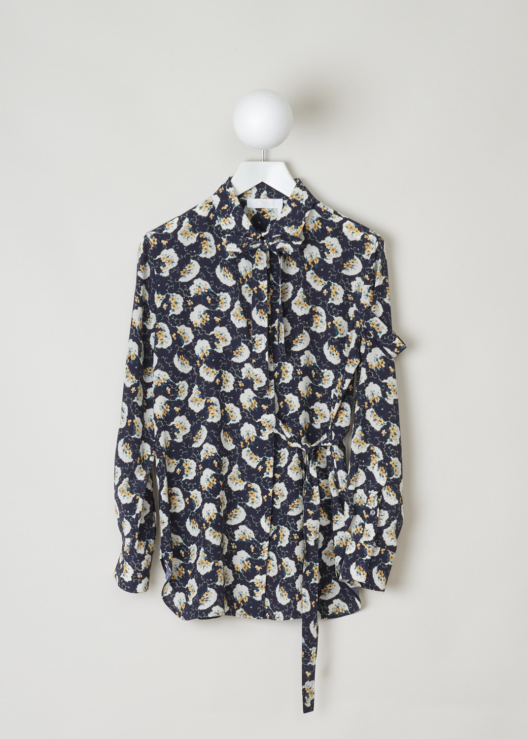 ChloÃ©, Navy blouse decorated with a colorful floral pattern, CHC20SHT40335476_476_dark_night_blue, blue, print, front, A silk crepe blouse adorned with a floral pattern in cream, yellow and green. Featuring a pointed collar which is accompanied by self-tie detail. a similar self-tie feature can be found on waist height and adds more excitement to this blouse. The fastening option here are the concealed buttons on the front.  