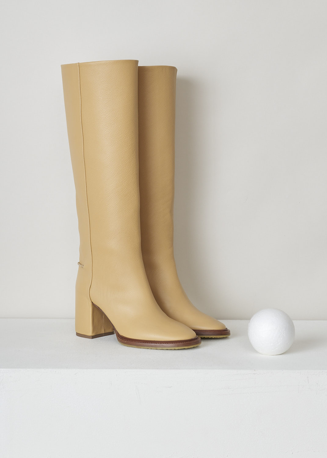 CHLOÃ‰, EDITH HEELED BOOTS IN SOFT TAN, CHC21W519V3275_EDITH_HEEL_BOOTS_SOFT_TAN, Beige, Front, These knee-high black leather slip-on boots have a blocked heel with stitched piping on the back shaft. The boots have a round toe and a contrasting brown sole.
