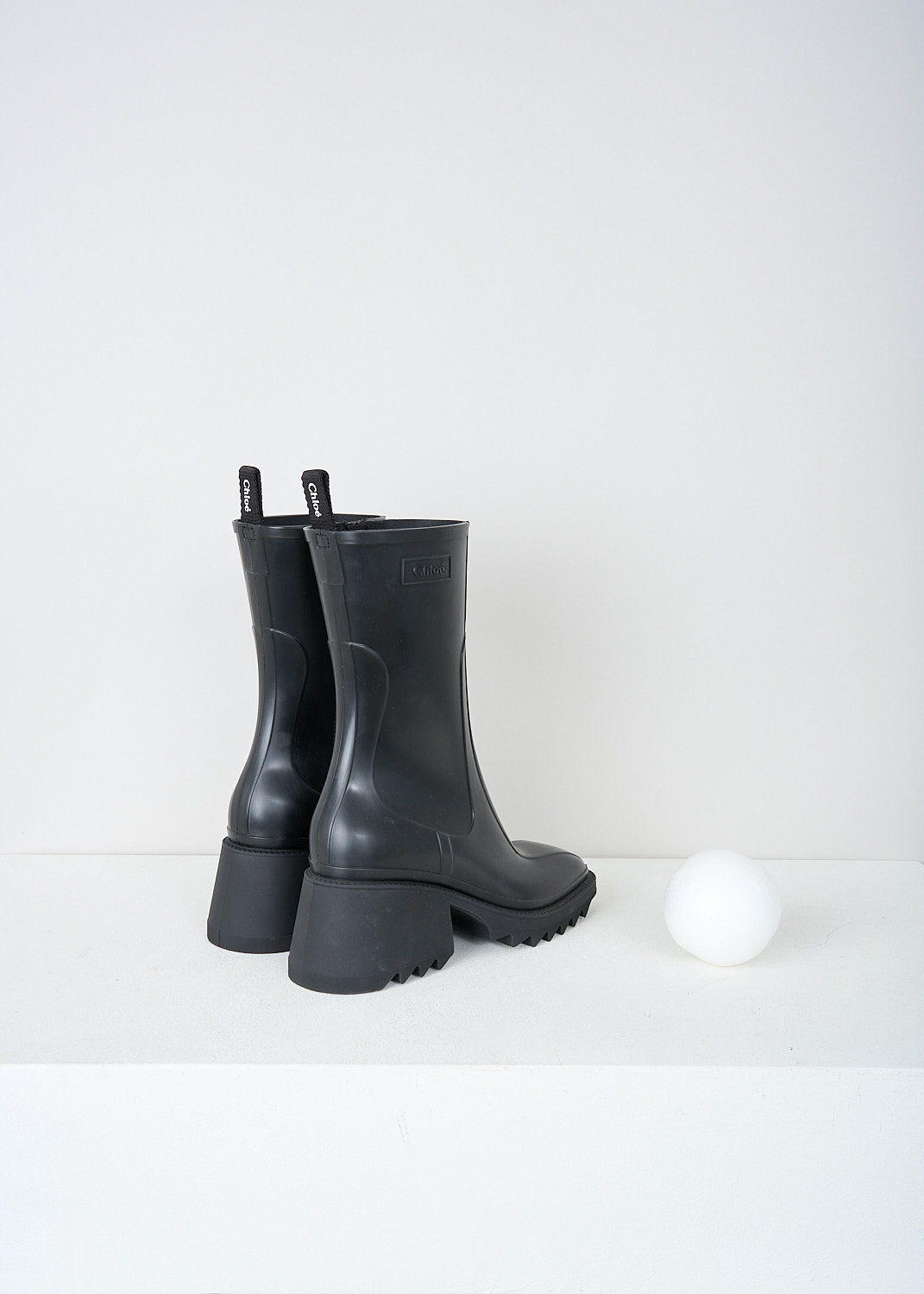 Chloé, Black Betty rain boots, CHC22A239Z2001_BETTY_RAINBOOTS, Black, Back, These black Betty rain boots have a side zipper and a pull tab on the back top edge. The brand's logo can be found debossed on the outside. These boots have a rounded square toe, ridged soled and a blocked heel. 


