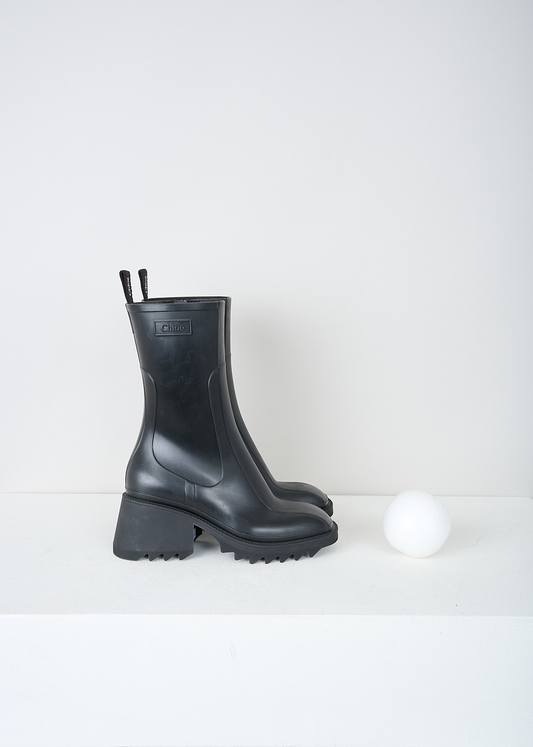 Chloé, Black Betty rain boots, CHC22A239Z2001_BETTY_RAINBOOTS, Black, Side, These black Betty rain boots have a side zipper and a pull tab on the back top edge. The brand's logo can be found debossed on the outside. These boots have a rounded square toe, ridged soled and a blocked heel. 


