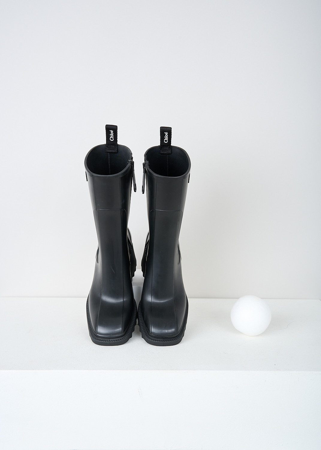 Chloé, Black Betty rain boots, CHC22A239Z2001_BETTY_RAINBOOTS, Black, Top, These black Betty rain boots have a side zipper and a pull tab on the back top edge. The brand's logo can be found debossed on the outside. These boots have a rounded square toe, ridged soled and a blocked heel. 

