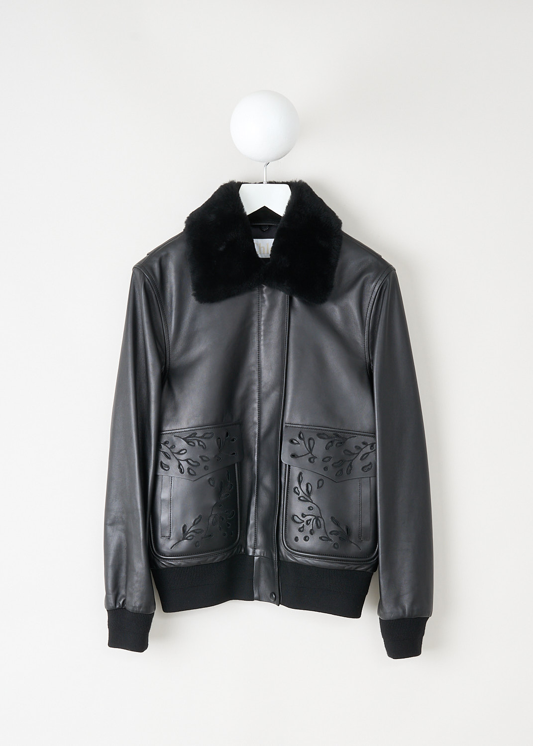 Black leather bomber with detachable fur collar, concealed front zip, and embroidered flap pockets by Chloé, available at designer boutique Kiki's Stocksale in Maastricht.