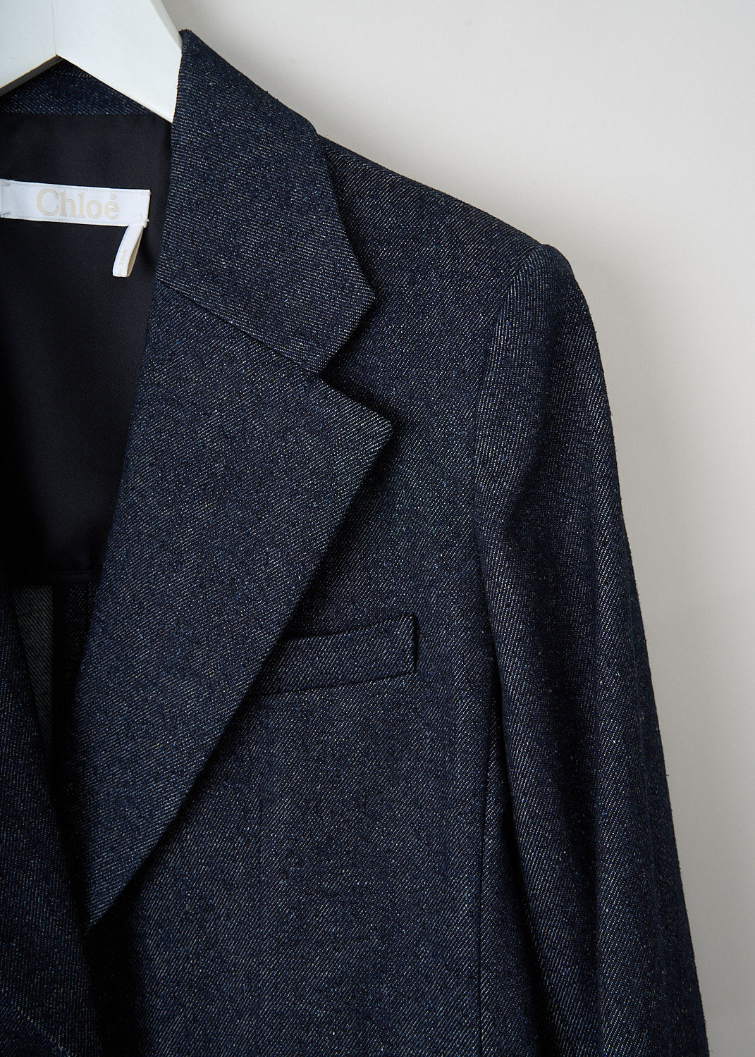 Chloé, Iconic navy denim jacket, CHC22ADV6115748A_ICONIC_NAVY, Blue, Detail, This iconic navy single-breasted denim jacket has a notched lapel and a front button closure. The long sleeves have buttoned cuffs. The jacket has a single breast pocket and two flap welt pockets. The jacket has a straight hemline with a double vent. The jacket is fully lined.


