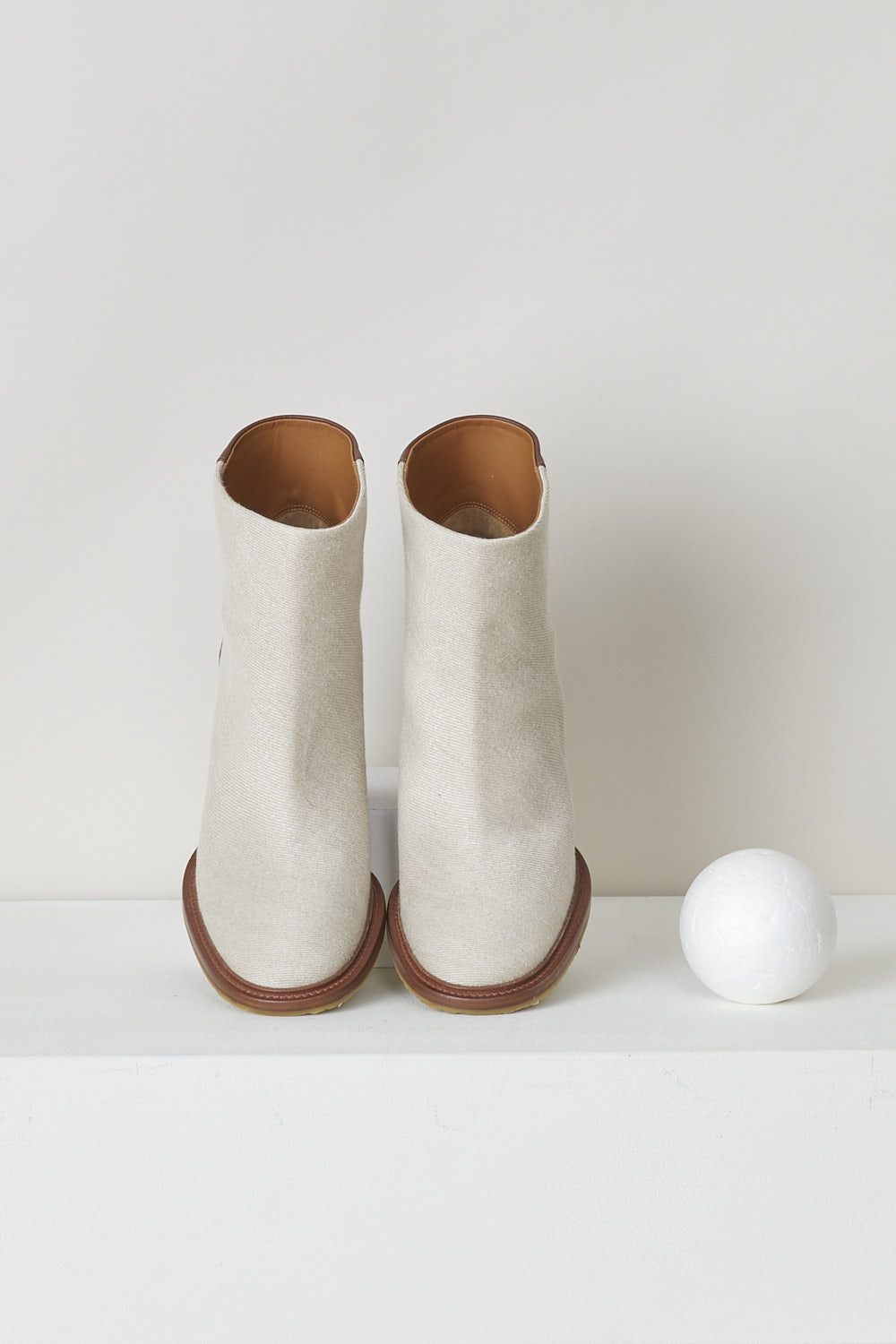 CHLOÉ, BEIGE EDITH ANKLE BOOT WITH BROWN HEEL, CHC22S521W89C, Beige, Brown, Top, These beige slip-on ankle boots have a brown leather-clad block heel with white stitching on the ankle. The boots have a round toe and a contrasting brown sole. 
