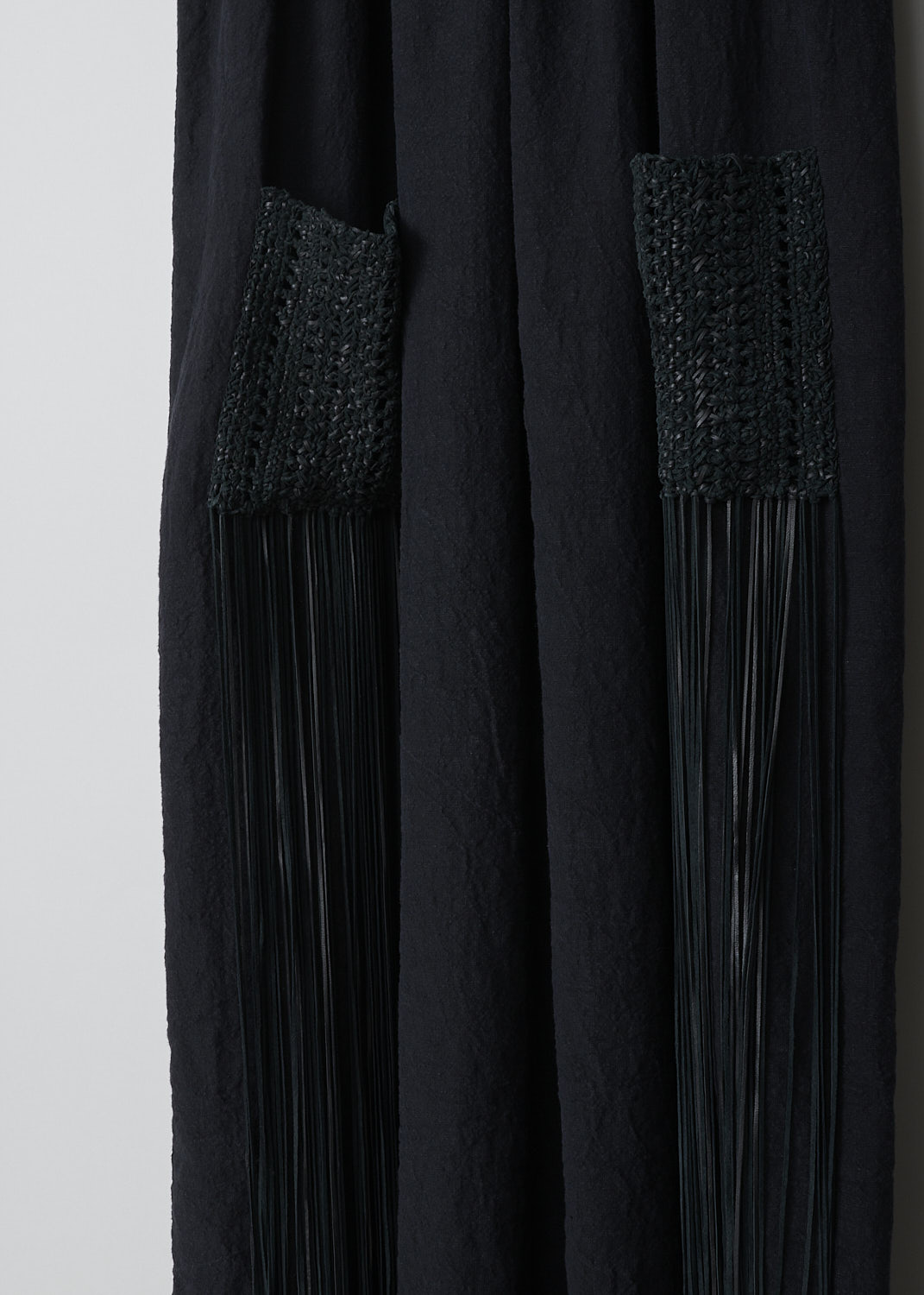 CHLOÉ, SLEEVELESS MULTI-FABRIC DRESS, CHC22SRO55035001_BLACK, Black, Detail 1, This sleeveless midi dress has a black leather bodice with a U-neckline. A braided leather belt separates the bodice from the black linen maxi length skirt. On the skirt, two braided leather patch pockets with long fringes can be found. 

  
