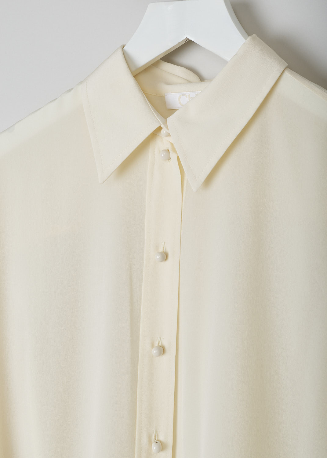 CHLOÉ, PRISTINE WHITE SILK BLOUSE, CHC22UHT05004114, White, Detail, This silk Pristine White blouse has a classic collar and a button placket with round ceramic. The blouse has long sleeves with buttoned cuffs.  A centre box pleat runs vertically down the back.
