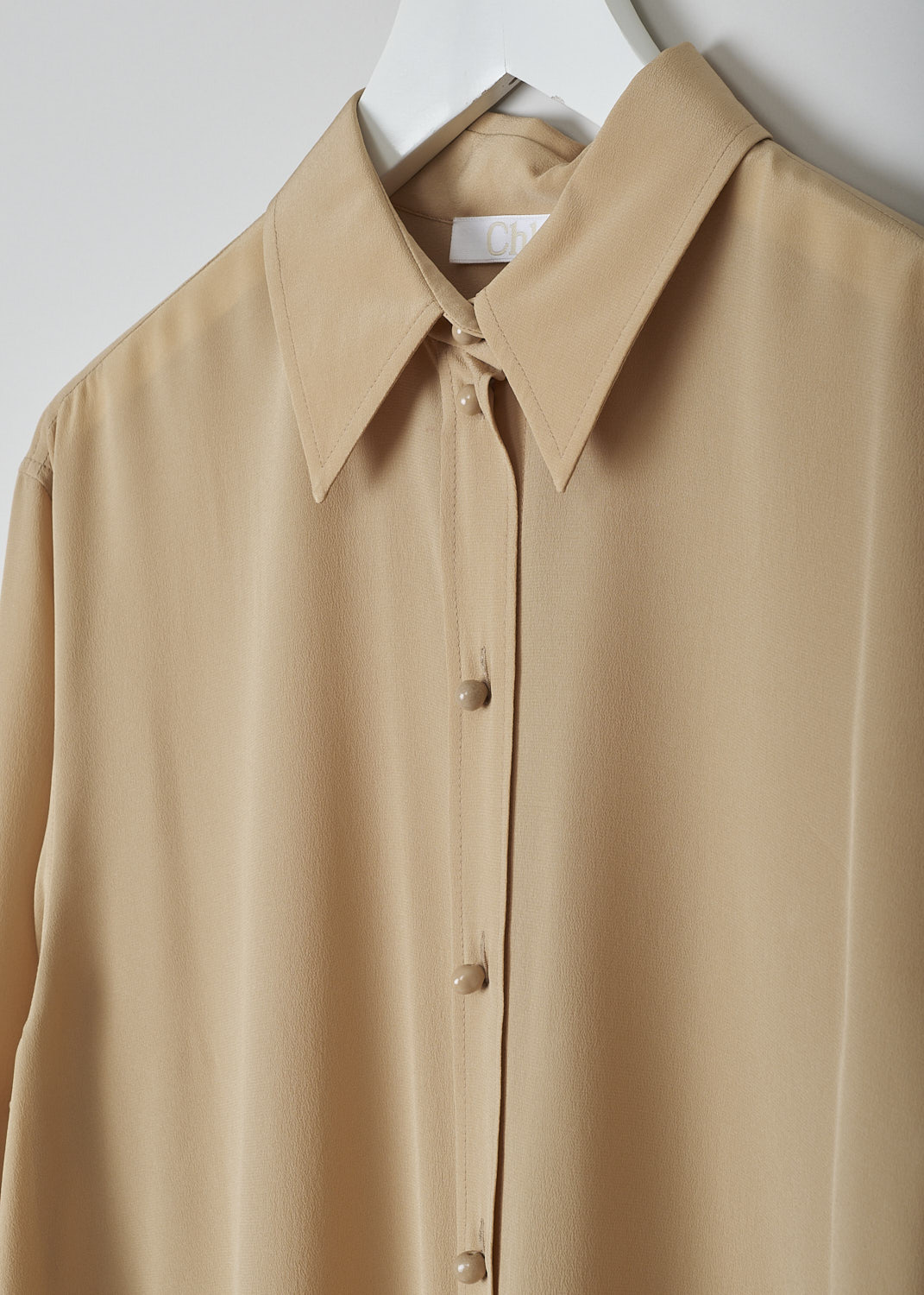 CHLOÉ, PEARL BEIGE BLOUSE, CHC22UHT05004278, Beige, Detail, This silk pearl beige blouse has a classic collar and a button placket with round ceramic. The blouse has long sleeves with buttoned cuffs.  A centre box pleat runs vertically down the back.

