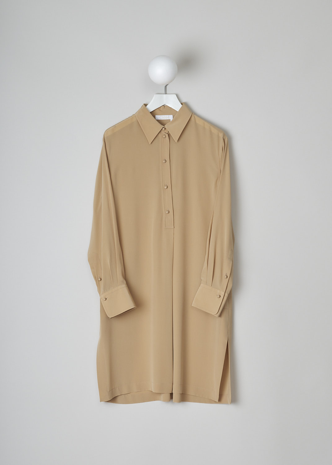CHLOÉ, PEARL BEIGE SILK SHIRT DRESS, CHC22URO64004278, Beige, Front, This pearl beige silk dress has a classic collar and a partial button placket with round ceramic buttons. Below the placket, a single knife pleats goes down to the hemline. This loose-fitted dress has long sleeves with buttoned cuffs. Slanted pockets are concealed in the side seam. The dress has side slits and an asymmetrical finish, meaning the back is a little longer than the front. A centre box pleat runs vertically down the back.